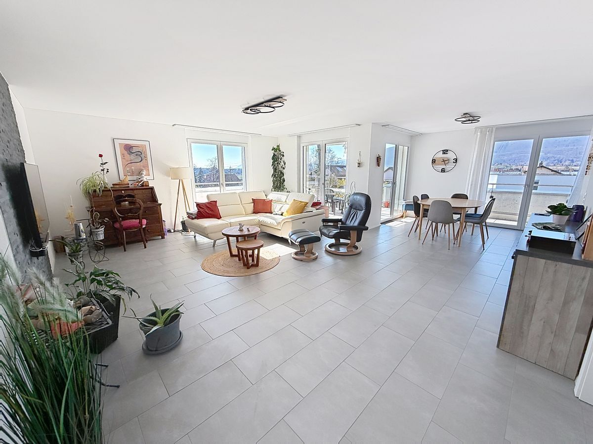 Espace ouvert avec coin salon et salle à manger lumineux.