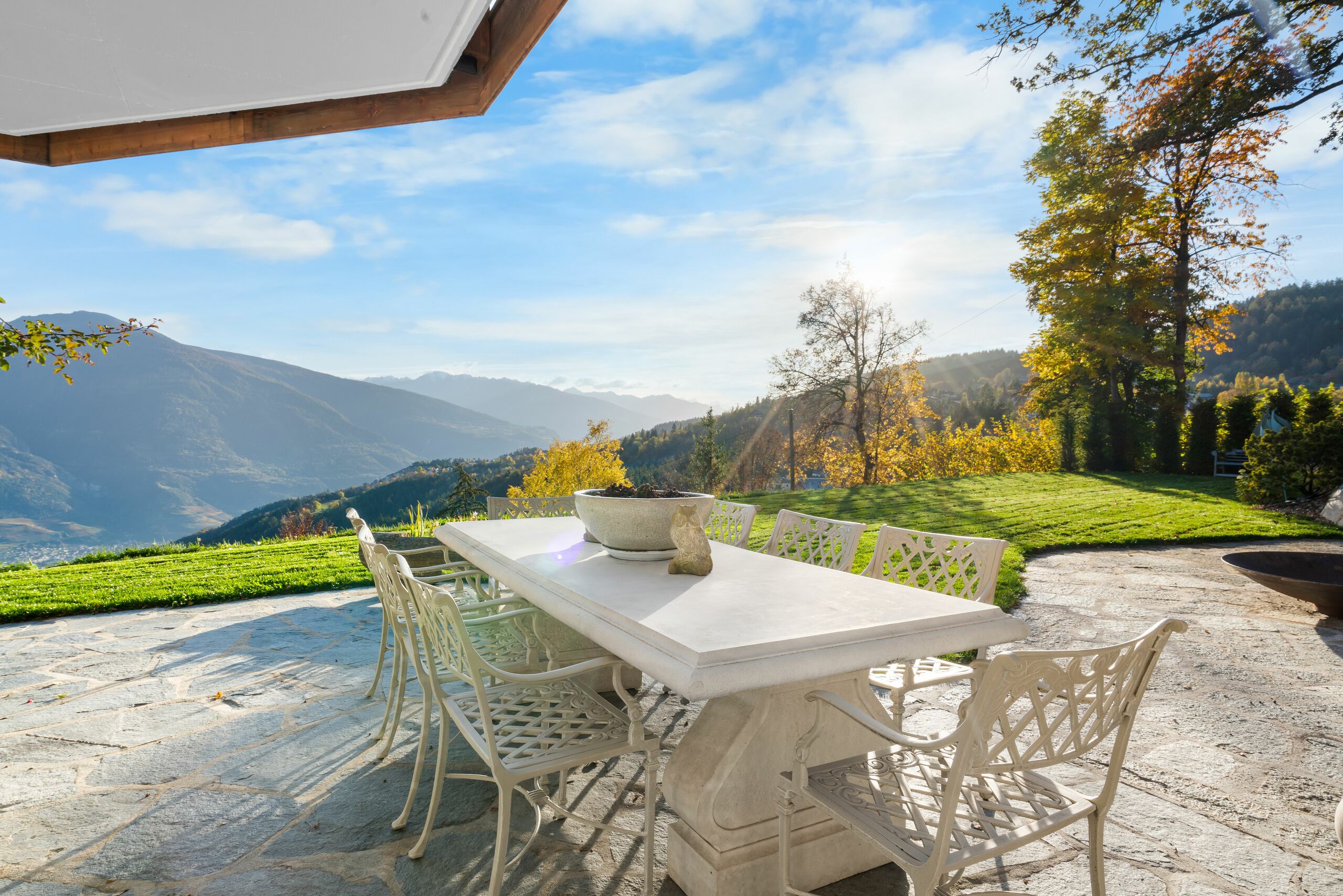 a table and chairs on a patio overlooking a valley and mountains