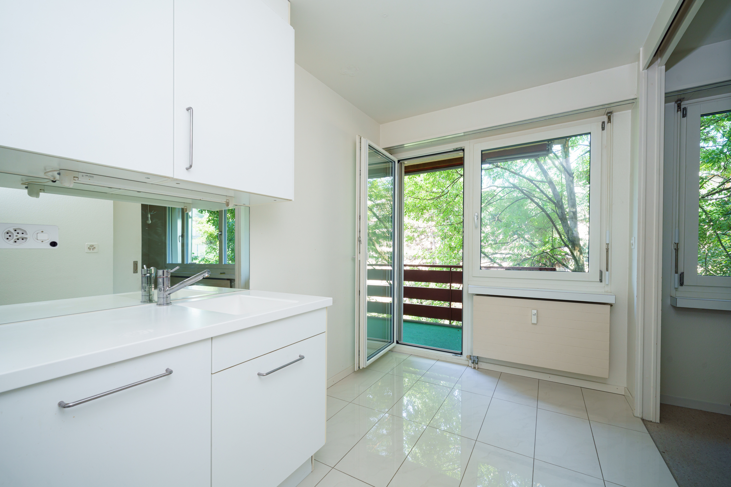 ein modernes Badezimmer mit weißen Schränken, einem großen Fenster und einer Glasschiebetür zu einem anderen Raum ein modernes Badezimmer mit weißen Schränken, einem großen Fenster und einer Glasschiebetür zu einem anderen Raum
