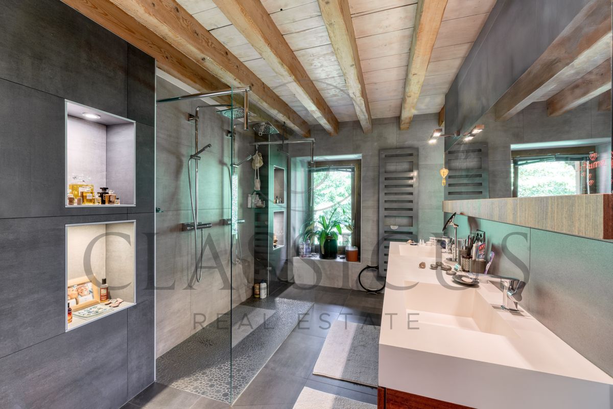 Douche moderne avec double vasque et poutres apparentes.