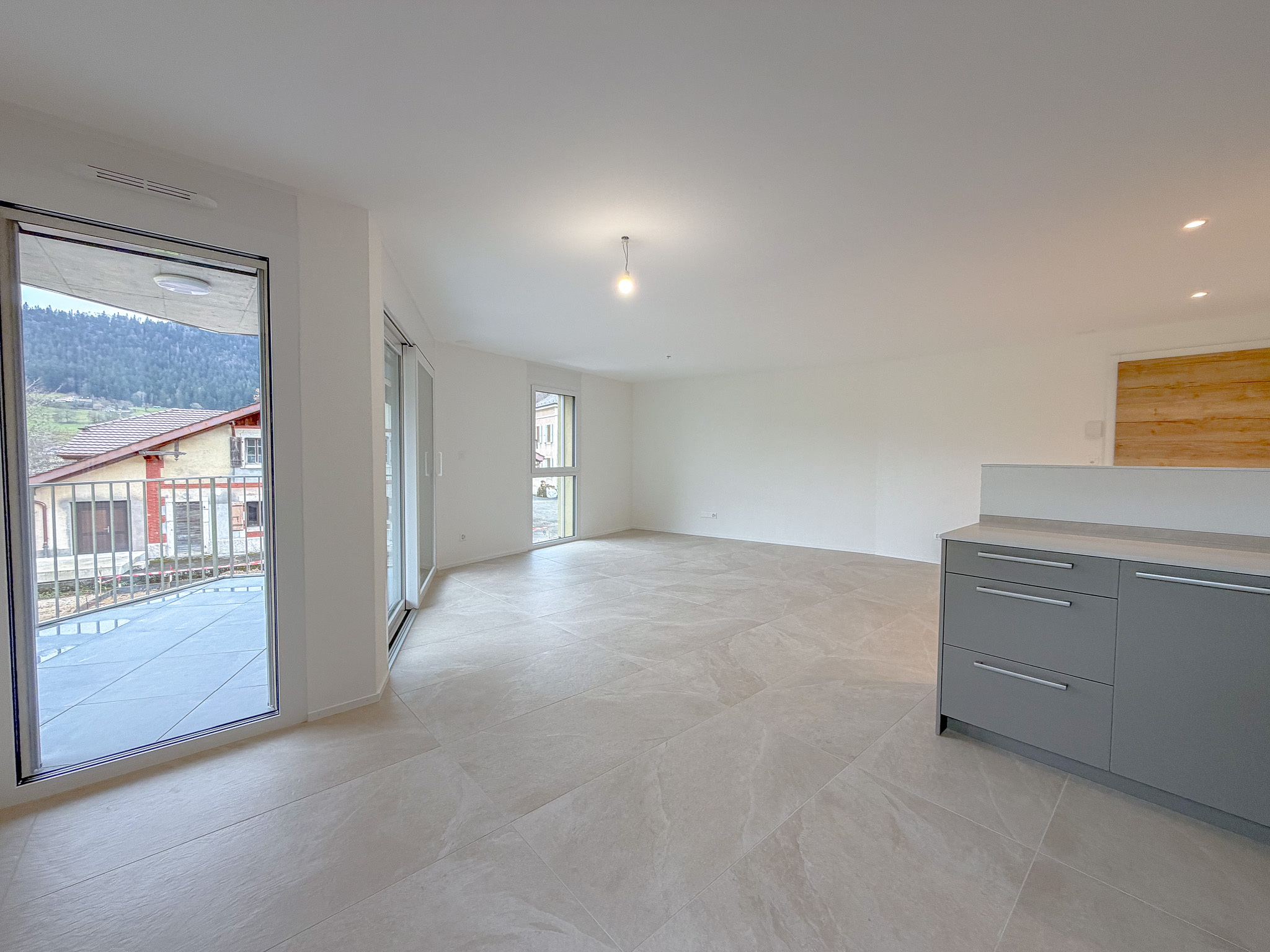 Espace salon/séjour avec portes-fenêtres donnant accès au balcon