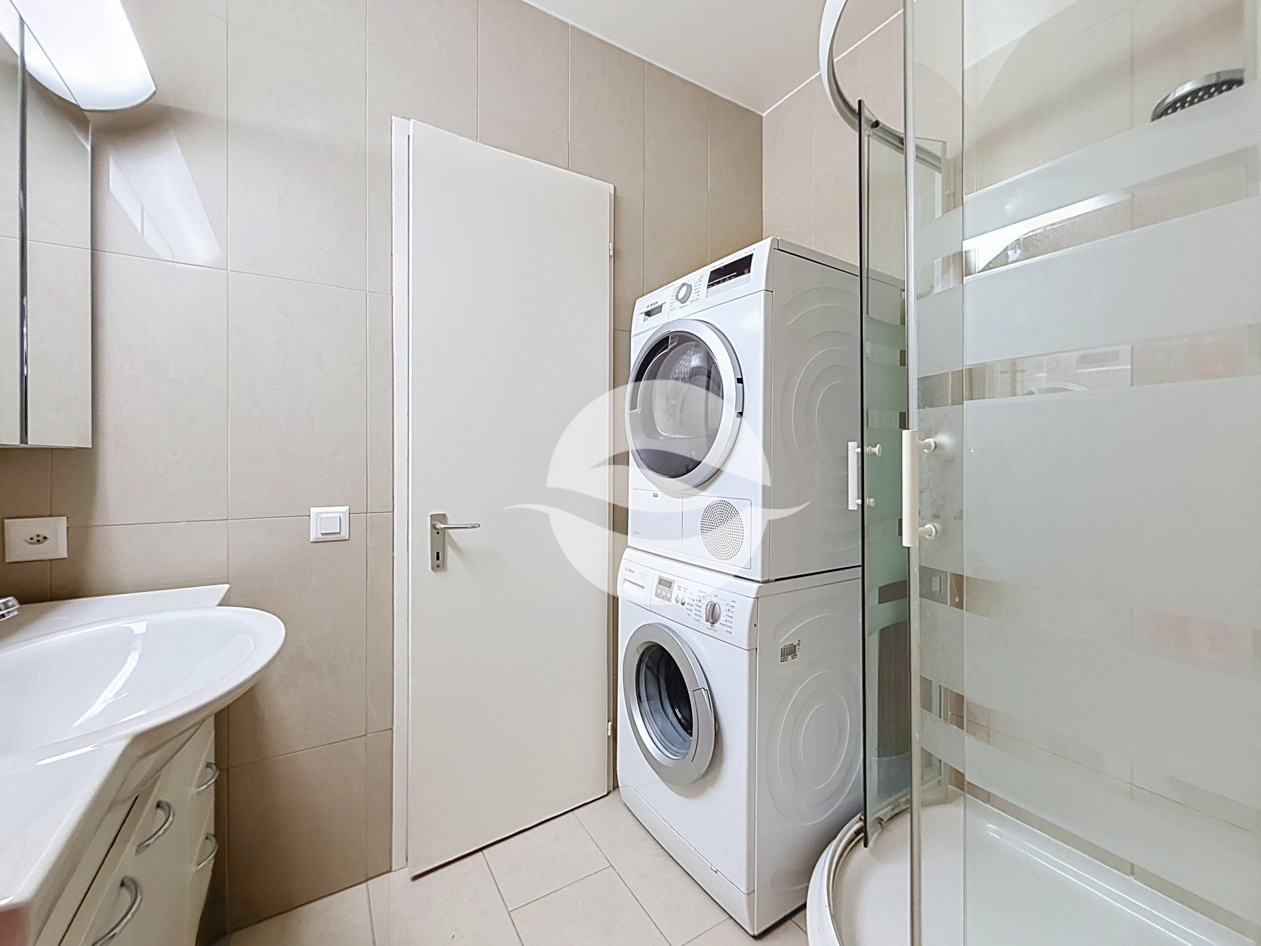 Salle de douche avec colonne lave-linge et séchoir