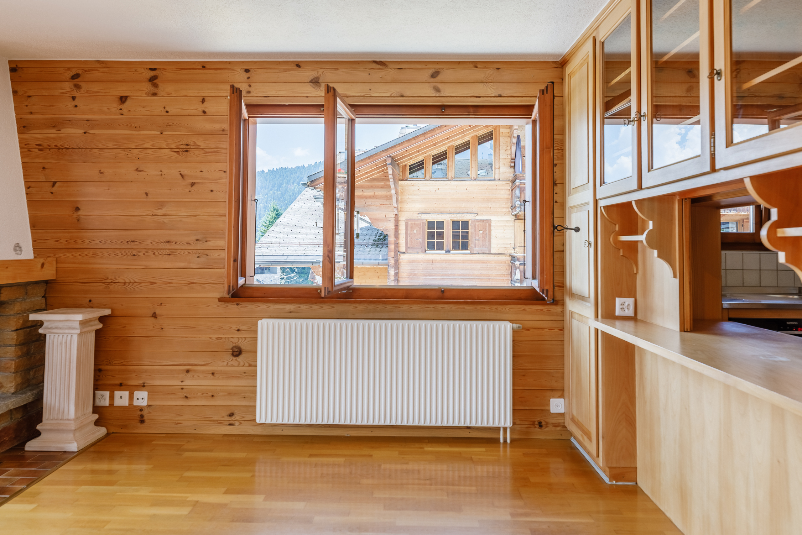 l'intérieur d'une maison avec des murs et des planchers en bois, une cheminée et de grandes fenêtres