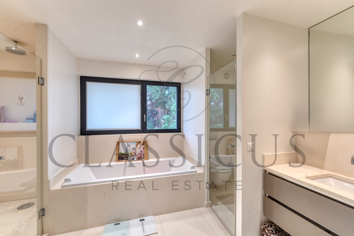 Salle de bain moderne avec baignoire et douche.