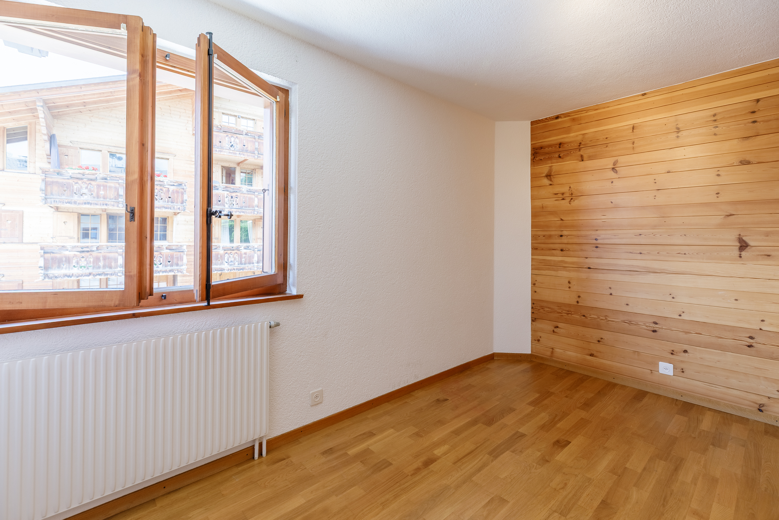 une pièce vide avec des murs en bois et une grande fenêtre