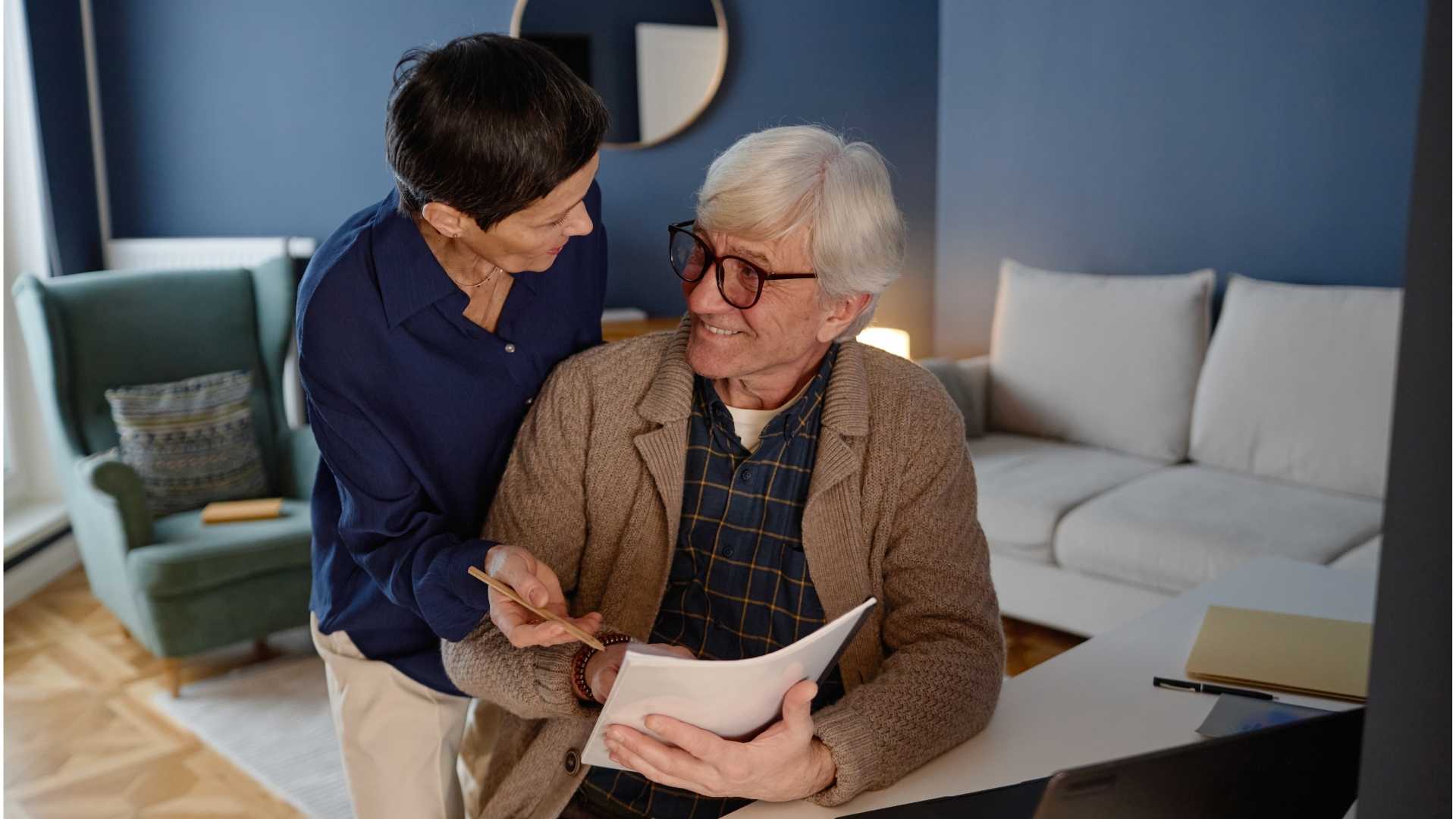 Couple senior examinant des documents financiers à domicile.