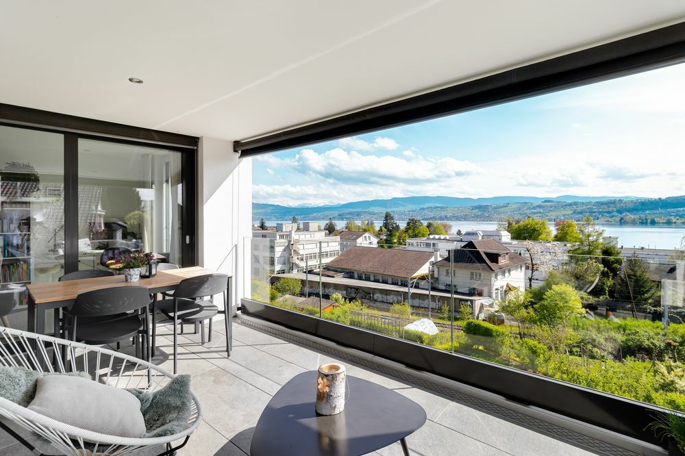 eine moderne Wohnung mit einem Balkon und großen Fenstern mit Blick auf die Stadt eine moderne Wohnung mit einem Balkon und großen Fenstern mit Blick auf die Stadt