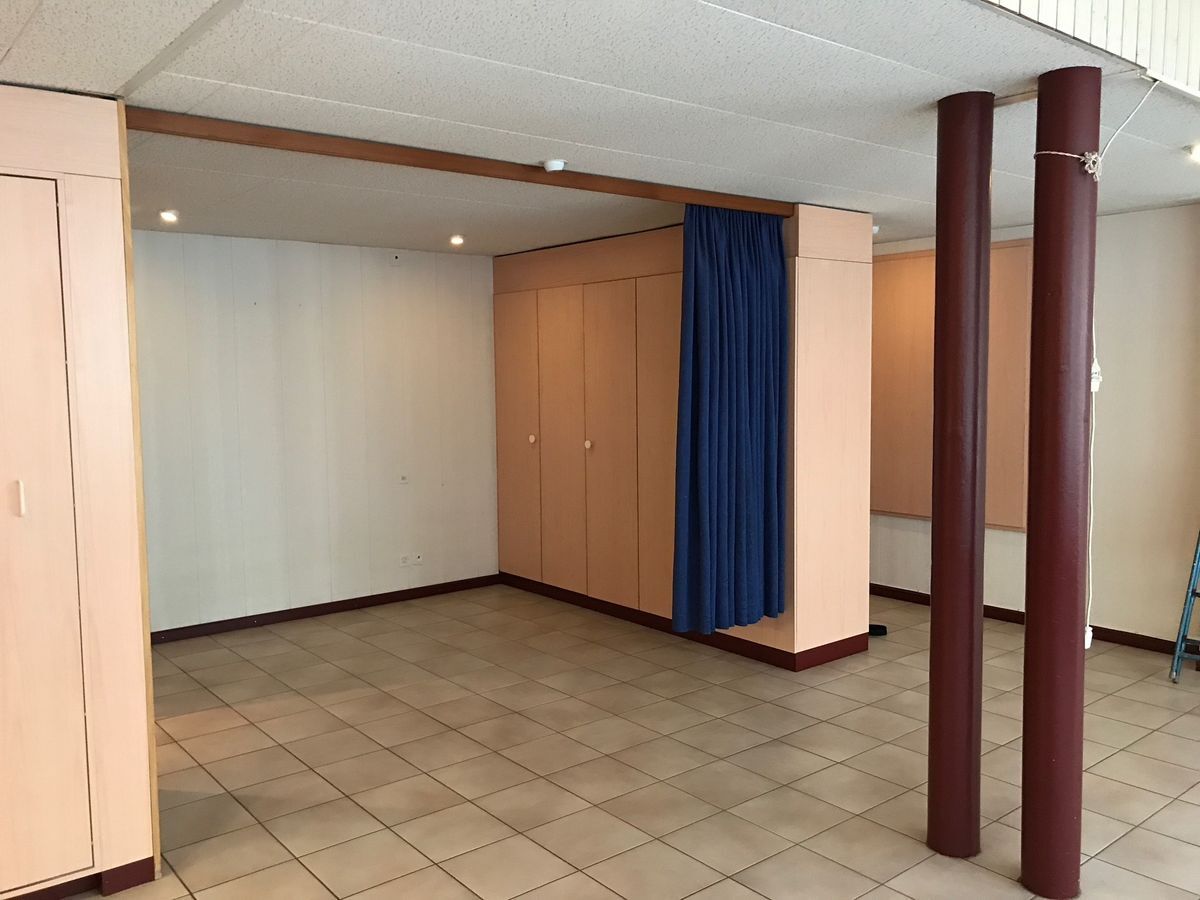 Espace carrelé avec placards et rideau bleu.