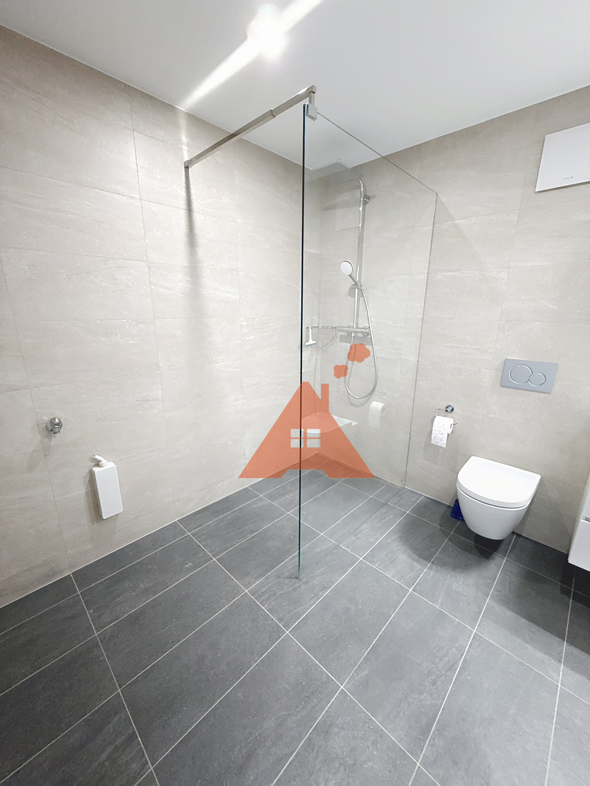 une salle de bains avec une grande douche et des toilettes blanches à l'étage une salle de bains avec une grande douche et des toilettes blanches à l'étage