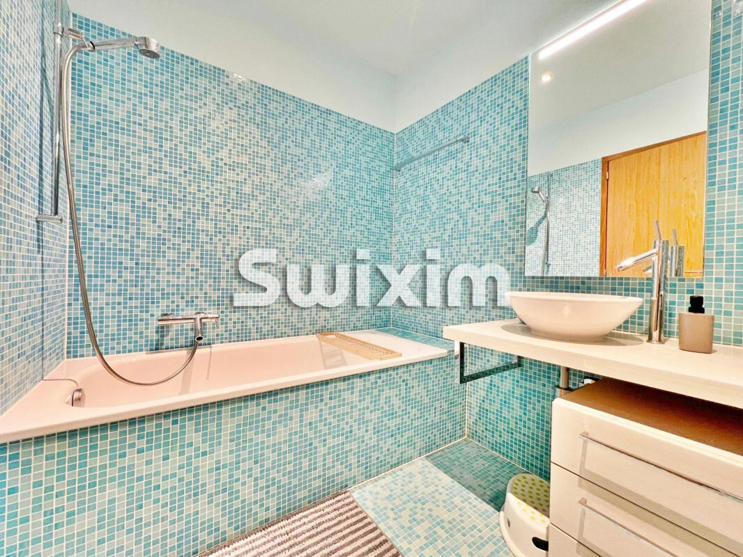 Salle de bain moderne avec mosaïques bleues, baignoire, lavabo blanc et miroir. Salle de bain moderne avec mosaïques bleues, baignoire, lavabo blanc et miroir.
