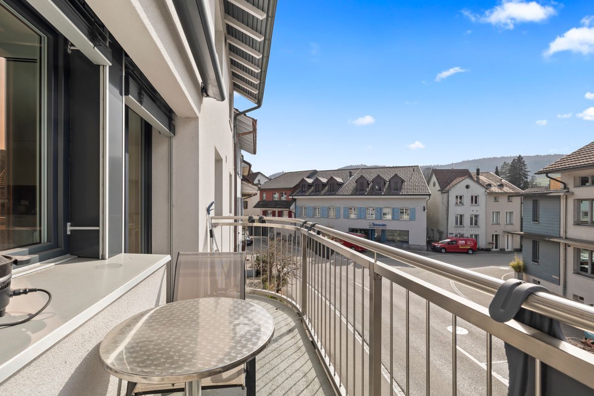 Balkon mit Blick auf die Straße und umliegende Gebäude.