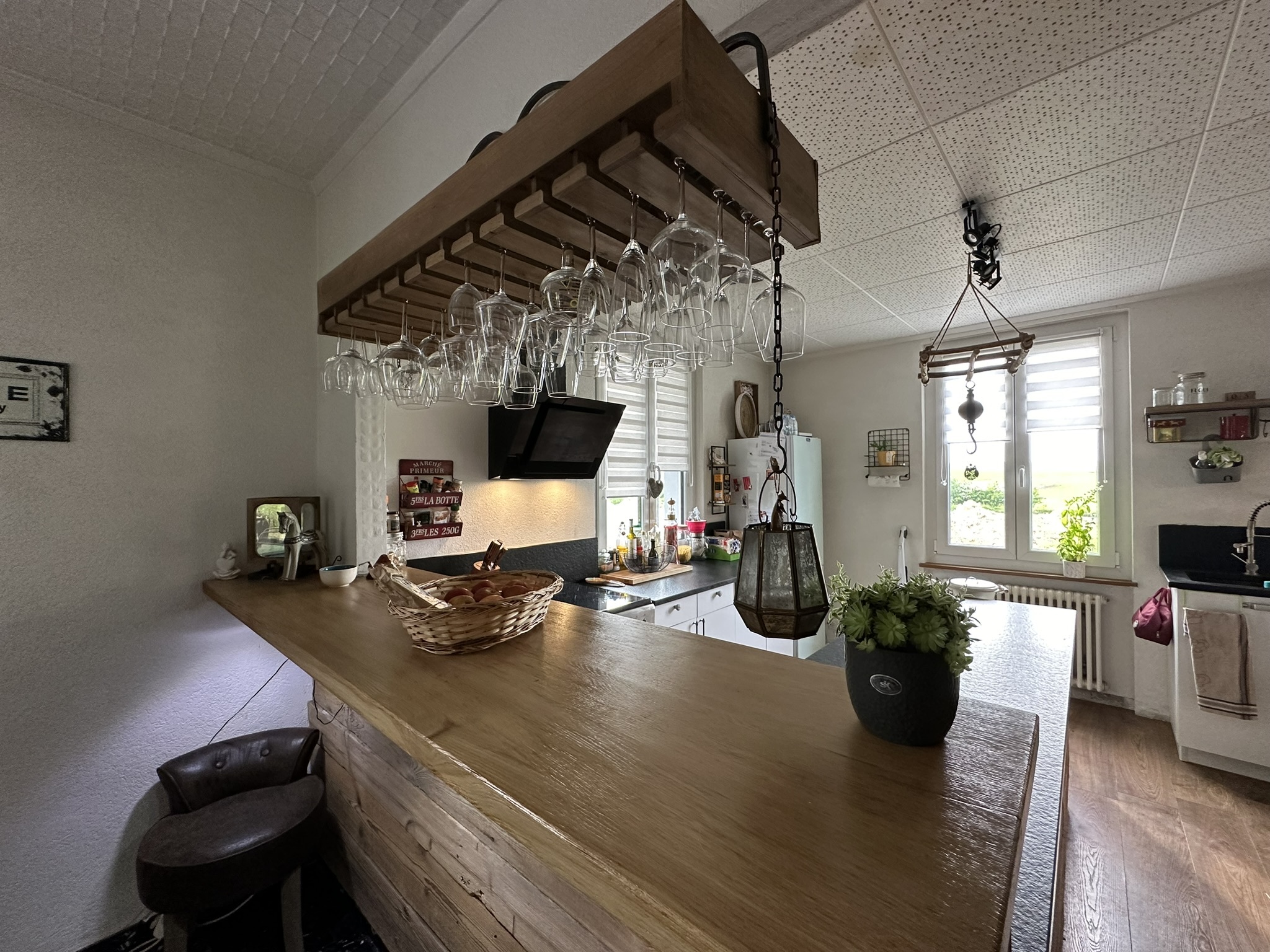 une cuisine avec un bar et une table en bois