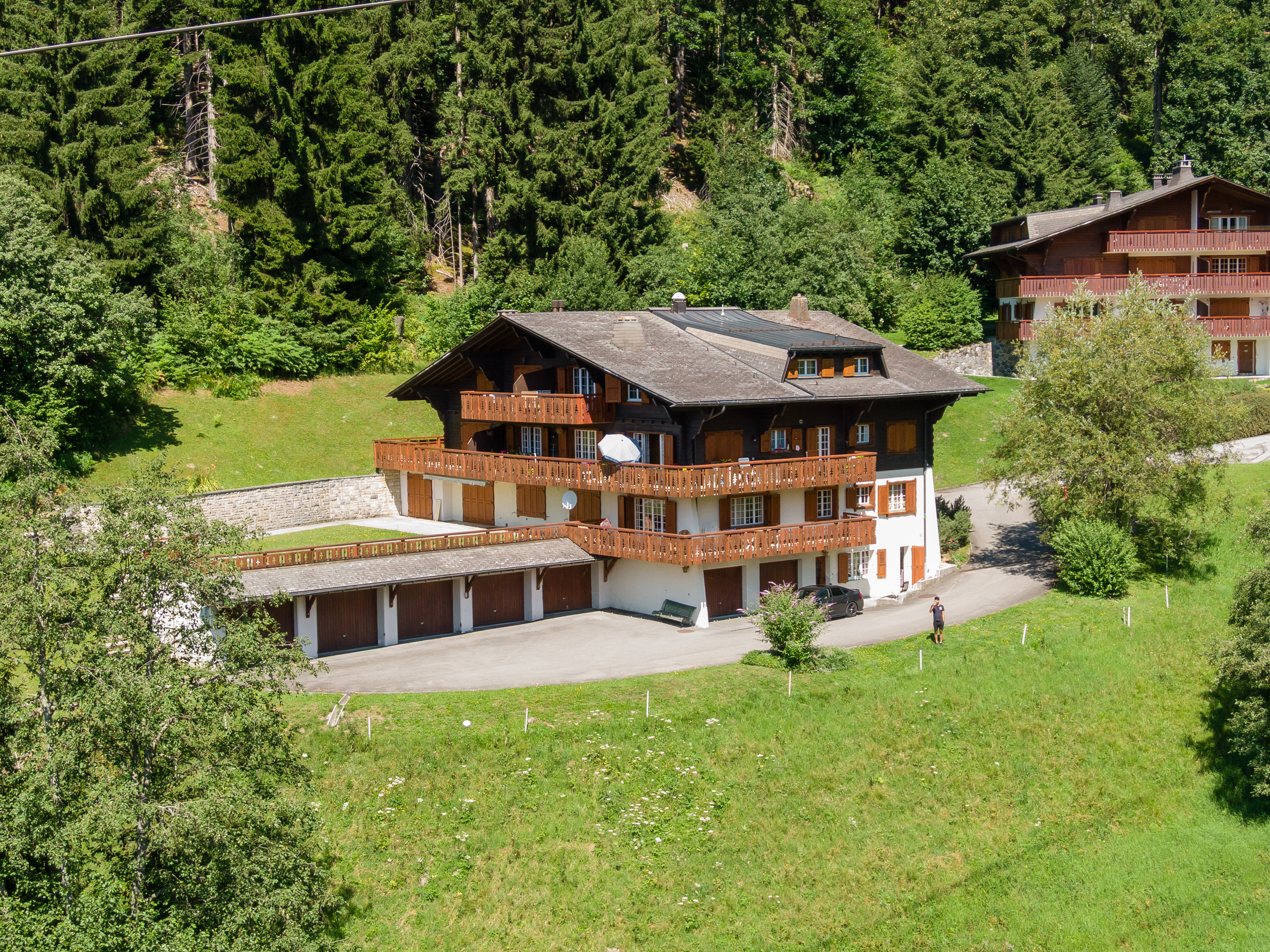 une grande maison avec balcons sur une colline verdoyante une grande maison avec balcons sur une colline verdoyante