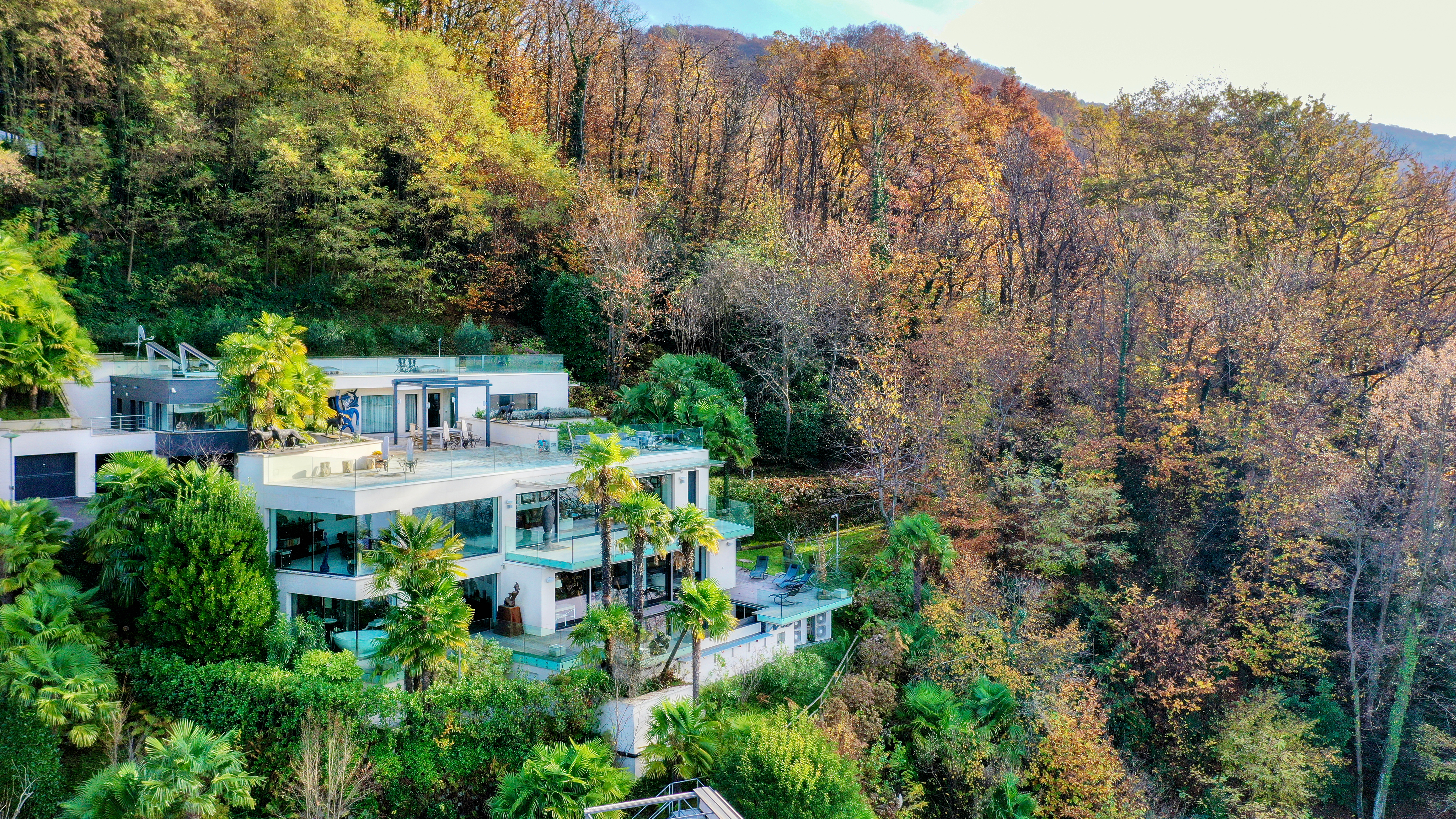 Ultra Moderna Villa di Lusso con Vista Lago di Lugano a Montagnola A Montagnola (Collina d'Oro), in prestigioso quartiere residenziale, tranquillo e soleggiato, a ca. 10 minuti d'auto dal centro di Lugano e dalla scuola americana TASIS, proponiamo in vendita questa splendida villa in stile contemporaneo, immersa nel verde, con vista sul lago di Lugano e sulle montagne circostanti.
La villa, orientata ad ovest, sorge su un terreno di 4'637 mq (di cui 3'511 mq bosco e 50 mq di particella a lago) e garantisce massima privacy e tranquillità.
La proprietà offre circa 440 mq abitativi su 3 livelli e ulteriori 400 mq di terrazze (con infinity pool riscaldata, cucina, BBQ, pergola), dispone di un appartamento ospiti indipendente e una darsena privata.
La villa è stata completamente rinnovata nel 2016 con materiali e rifiniture di pregio (Ralph Lauren, Rimadesio, Villeroy and Boch, Sicis, Poggenpohl, Swarovski, ecc.) e offre le ultime tecnologie all'avanguardia e il sistema di domotica di ultima generazione.
La villa è così suddivisa:
PIANO D'ENTRATA:
ingresso, ampio soggiorno, sala da pranzo, cucina accessoriata, WC, 2 camere da letto ognuna con guardaroba e bagno en-suite, patio, terrazze, giardino
PIANO INFERIORE:
camera da letto padronale con guardaroba separato e bagno en-suite, soggiorno, WC, zona fitness con sauna e doccia, lavanderia, terrazza con piscina a sfioro, giardino
APPARTAMENTO PER GLI OSPITI:
3 camere da letto con bagni en-suite bagni e guardaroba, cucina per gli ospiti completamente attrezzata con vista.
2 posti auto in garage separati, 5 esterni.