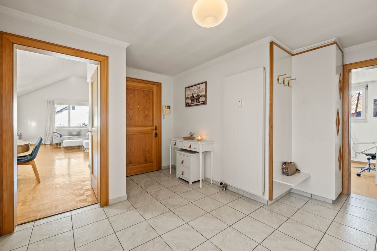 Geräumiger Eingangsbereich mit Fliesenboden und Sicht auf angrenzende Zimmer.