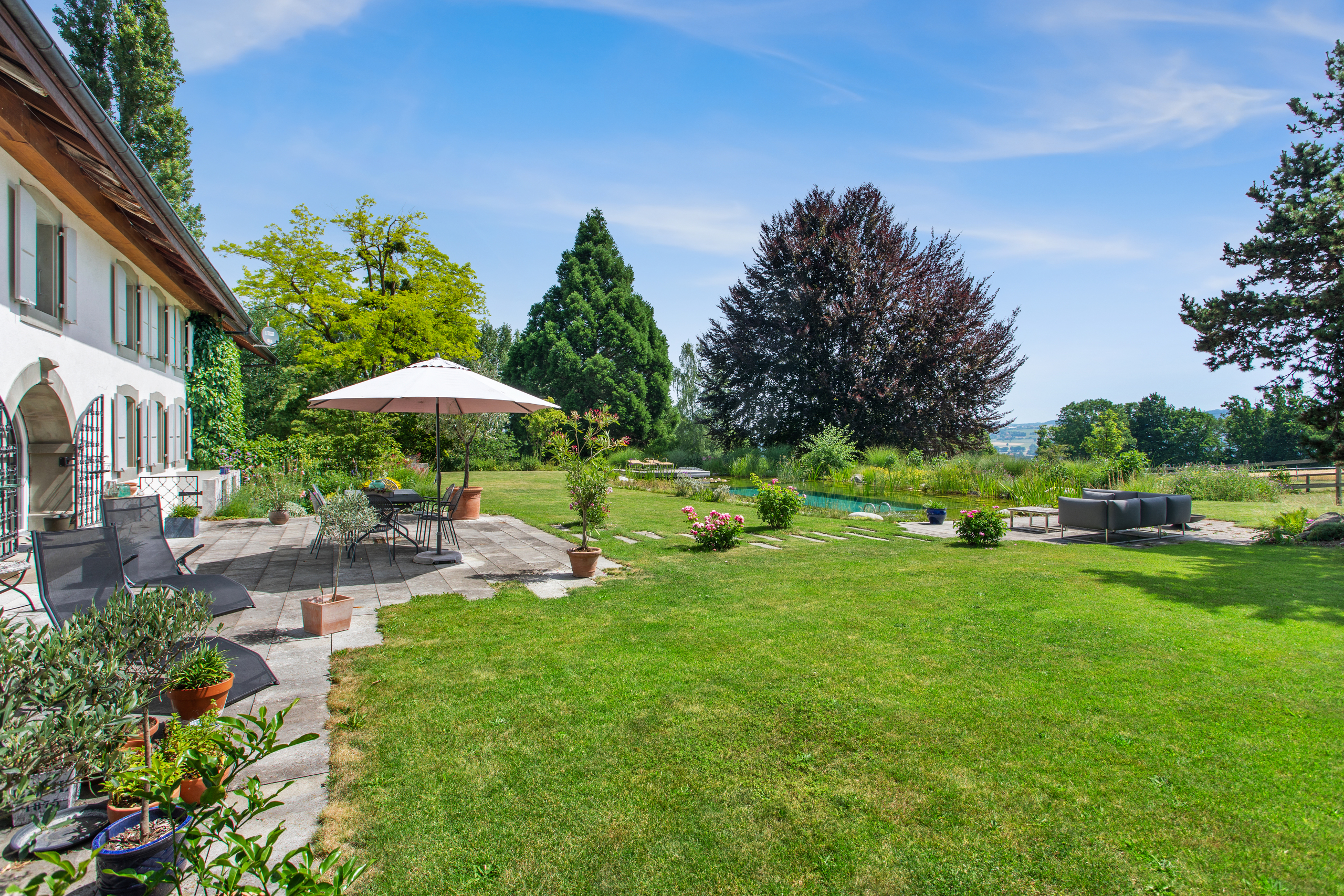 Terrasse et vaste jardin avec piscine à débordement
