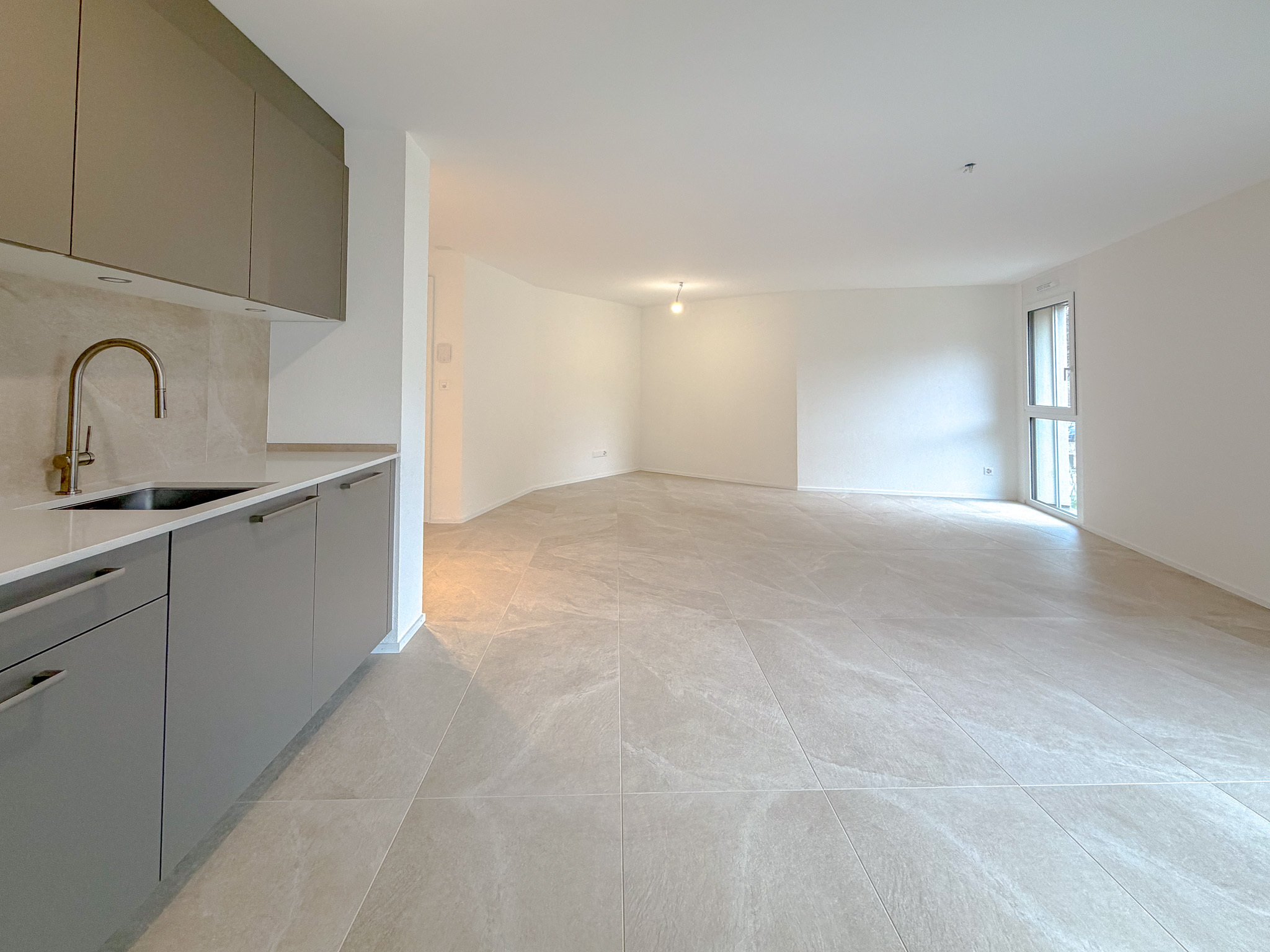 Espace salon/séjour avec portes-fenêtres donnant accès au balcon