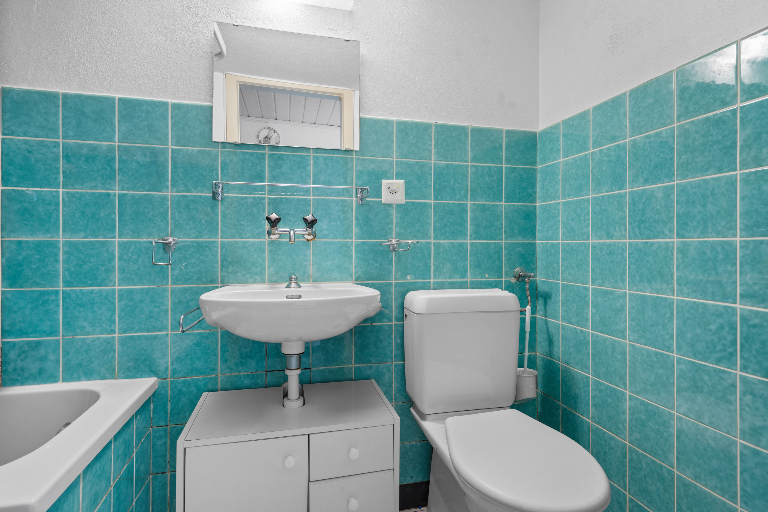 une petite salle de bains avec des carreaux bleus sur les murs et un lavabo blanc une petite salle de bains avec des carreaux bleus sur les murs et un lavabo blanc