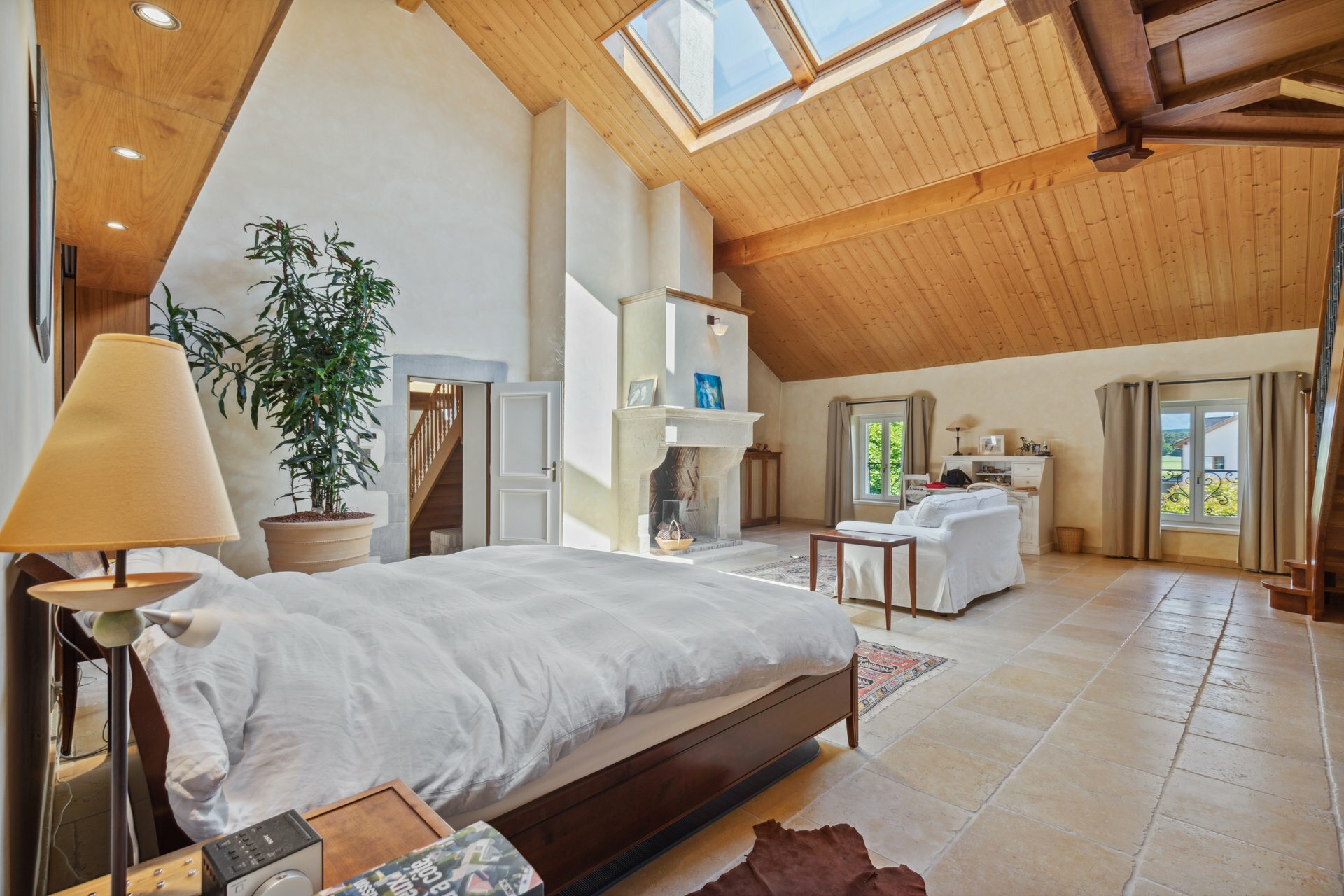 Vaste suite parentale avec cheminée et superbe hauteur sous plafonds