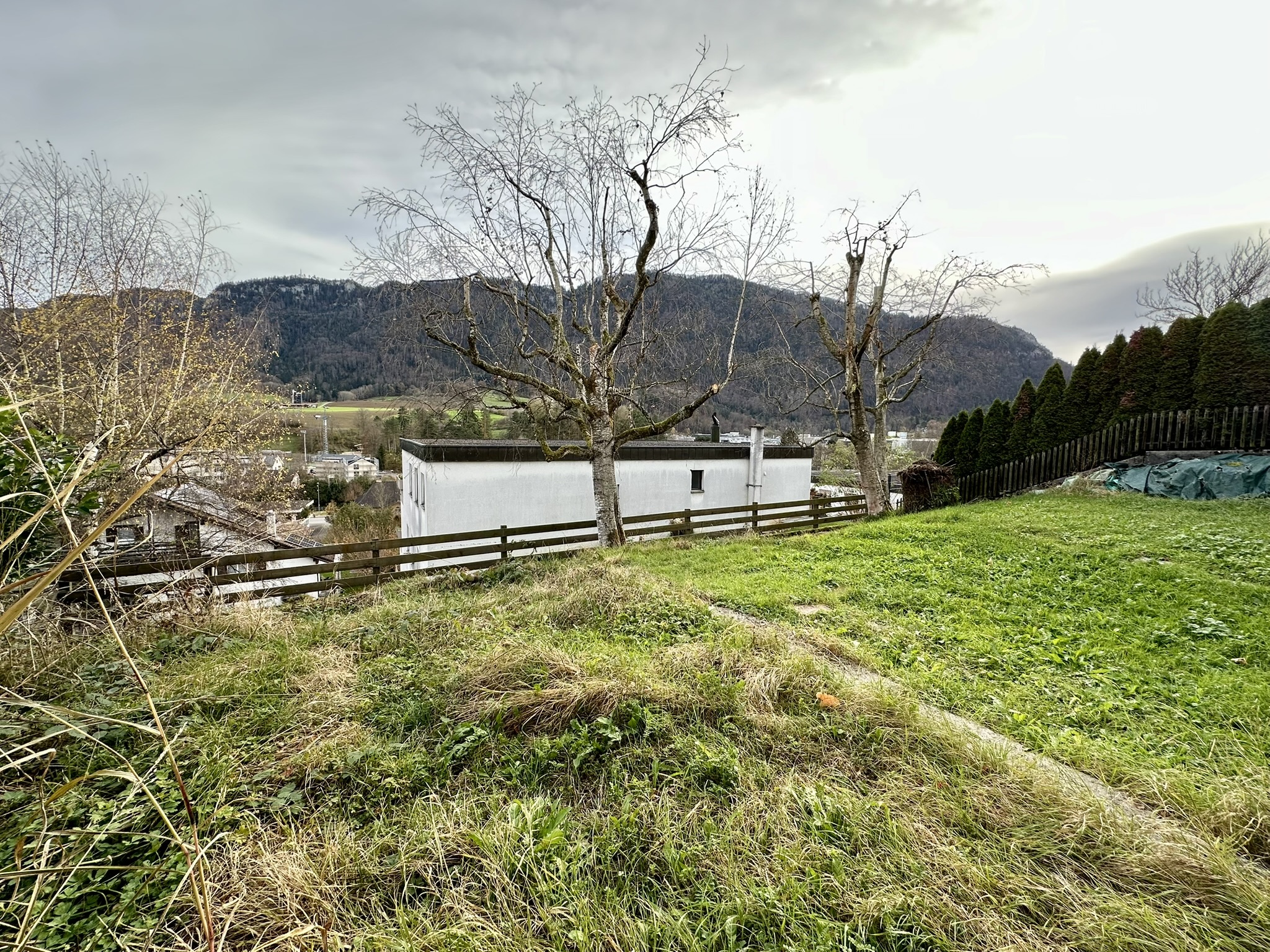 une petite maison sur une colline avec de l'herbe verte et une clôture blanche une petite maison sur une colline avec de l'herbe verte et une clôture blanche