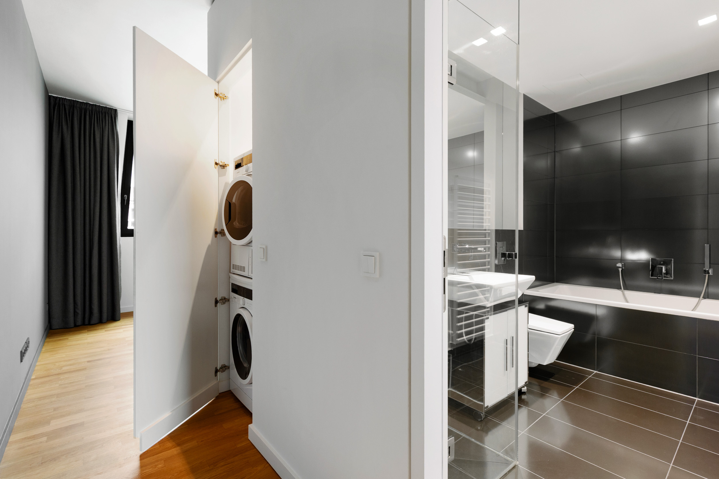 Auch das zweite Bad begeistert mit limitierten Libeskind-Fliesen, klarer Gestaltung und elegant integrierter Waschmaschine & Trockner. Auch das zweite Bad begeistert mit limitierten Libeskind-Fliesen, klarer Gestaltung und elegant integrierter Waschmaschine & Trockner.