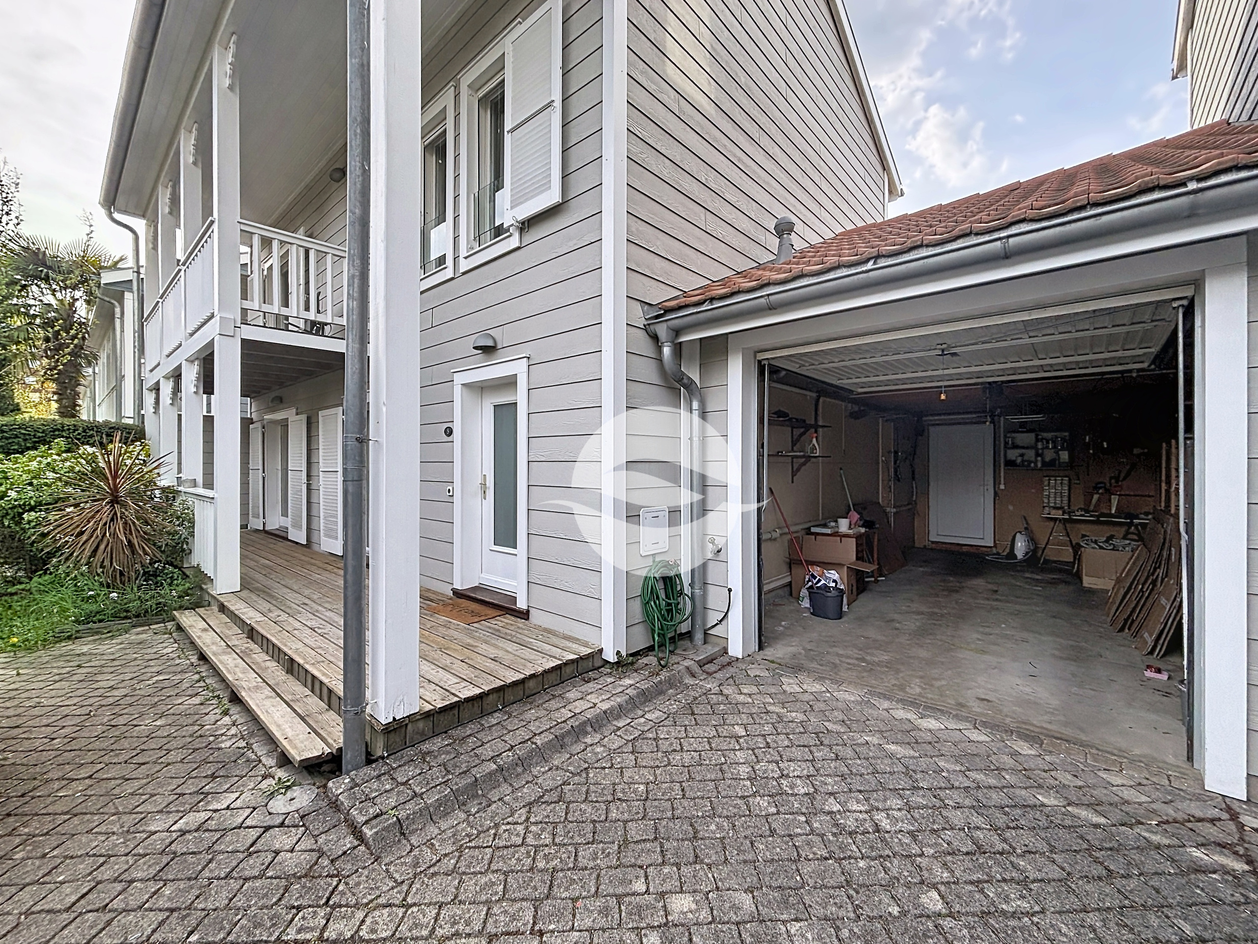 Garage avec porte électrique et place de parking devant le garage 