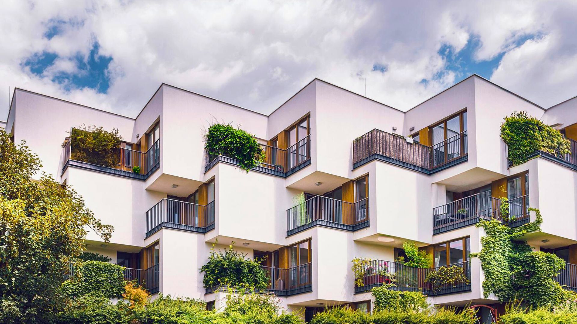 Modernes Wohngebäude mit Wohnungen, Balkonen und begrünten Aussen.bereichen als Beispiel für den Schweizer Immobilienmarkt.