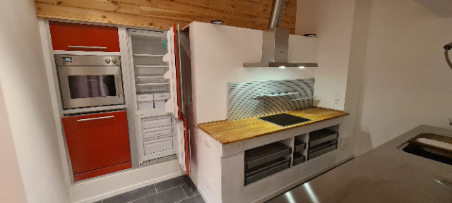 une cuisine équipée d'une cuisinière, d'un four, d'un évier, d'armoires et d'un réfrigérateur