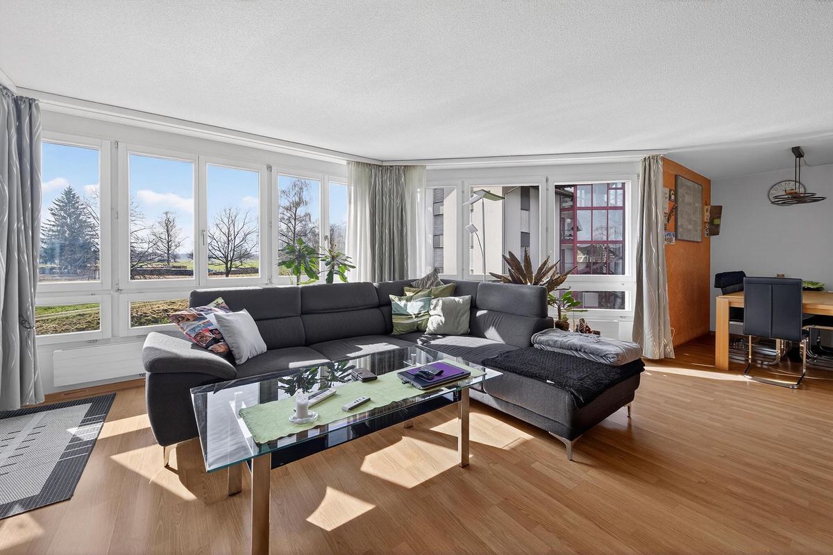 Helles Wohnzimmer mit grossen Fenstern und freier Fernsicht.