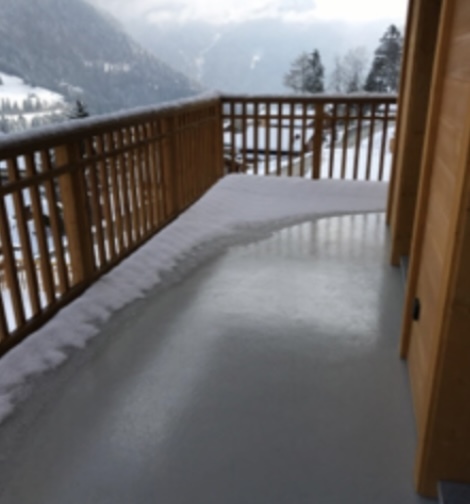 une terrasse en bois surplombant une montagne enneigée une terrasse en bois surplombant une montagne enneigée