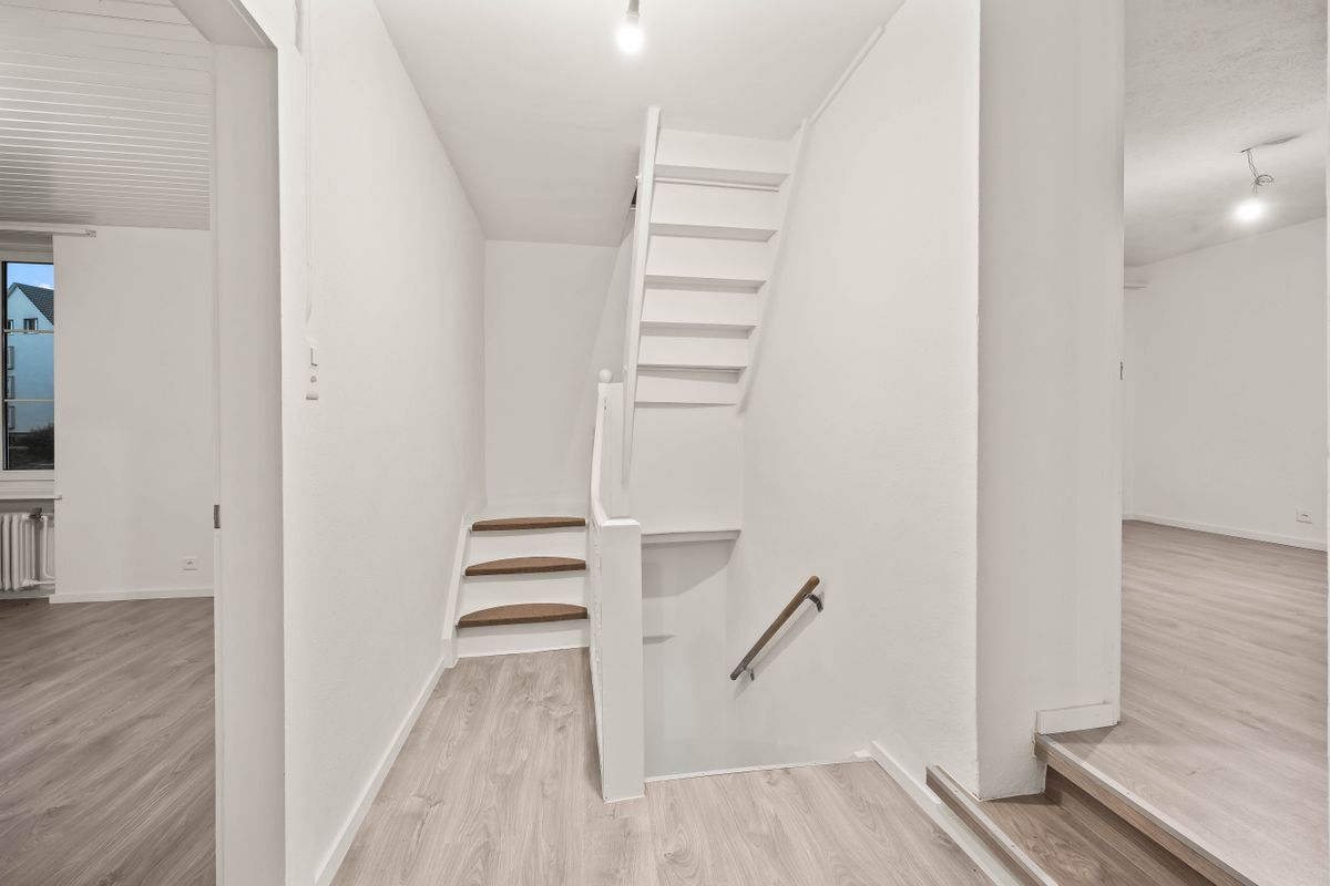 Modernes Treppenhaus mit Holzstufen und hellem Boden. Modernes Treppenhaus mit Holzstufen und hellem Boden.