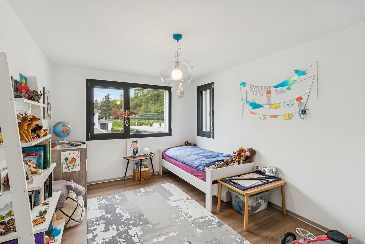 Chambre lumineuse avec lit simple et décorations ludiques.