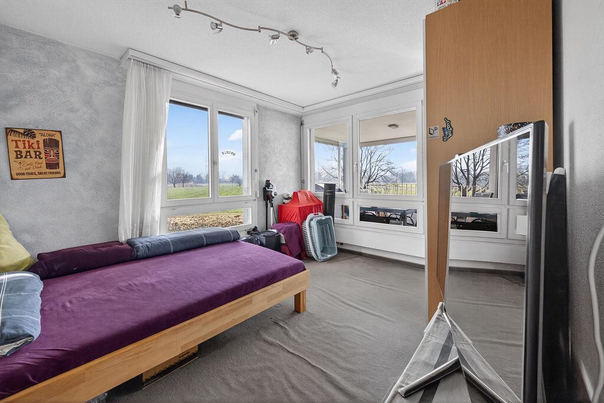Helles Zimmer mit grossen Fenstern und Blick ins Grüne.