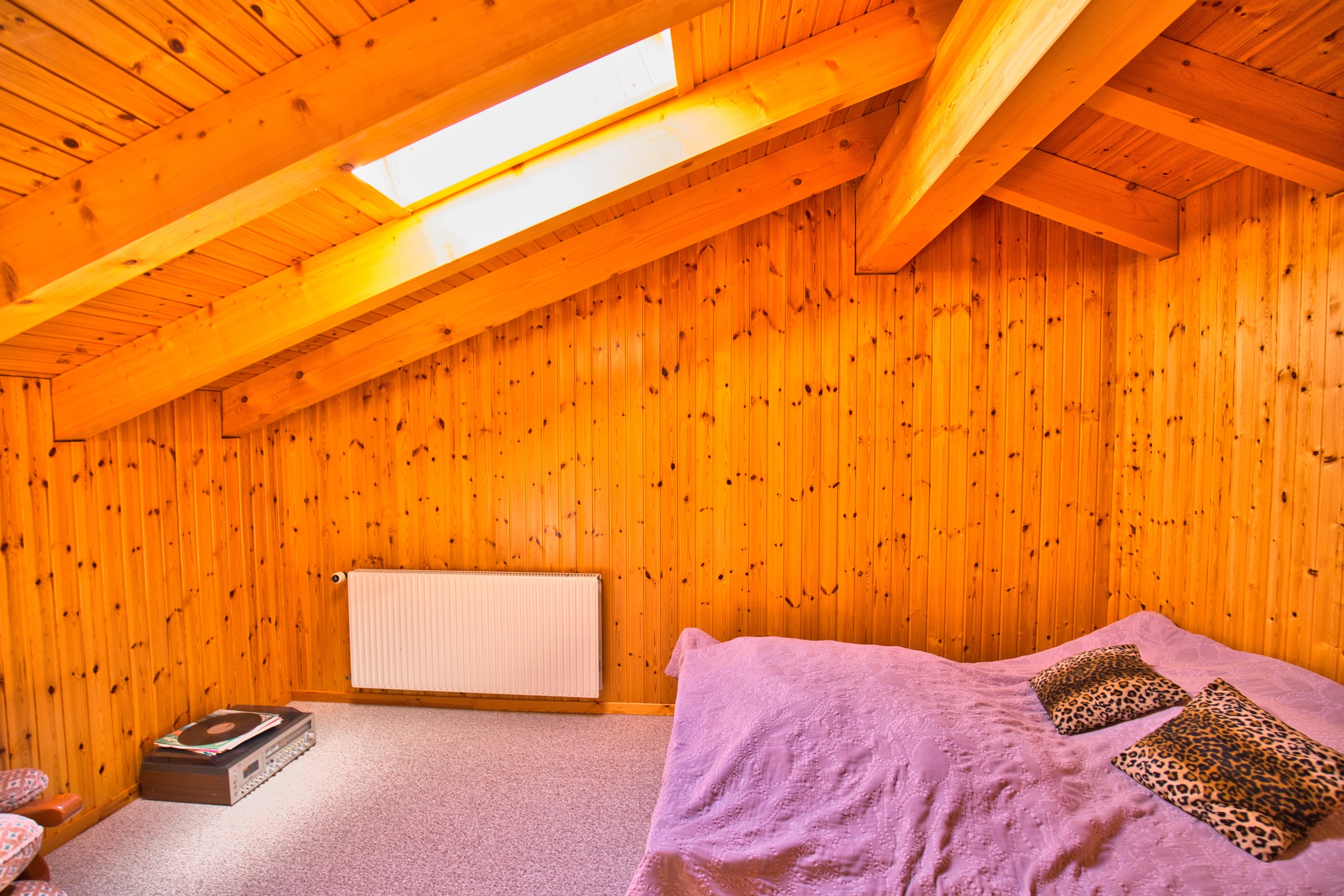 une chambre avec des murs et un plafond en bois et un grand lit une chambre avec des murs et un plafond en bois et un grand lit