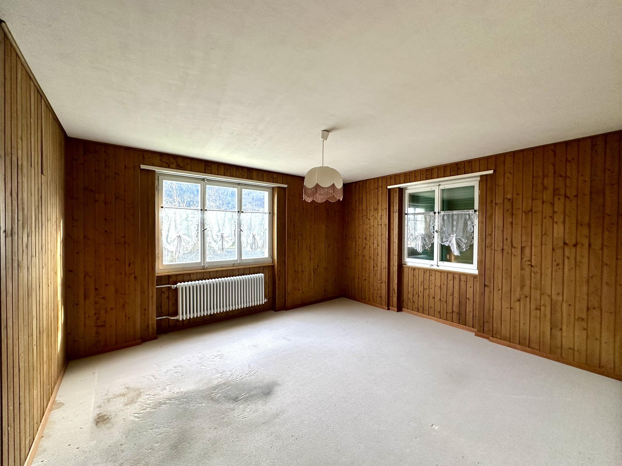 une pièce vide avec des murs en bois et une grande fenêtre dans une maison une pièce vide avec des murs en bois et une grande fenêtre dans une maison