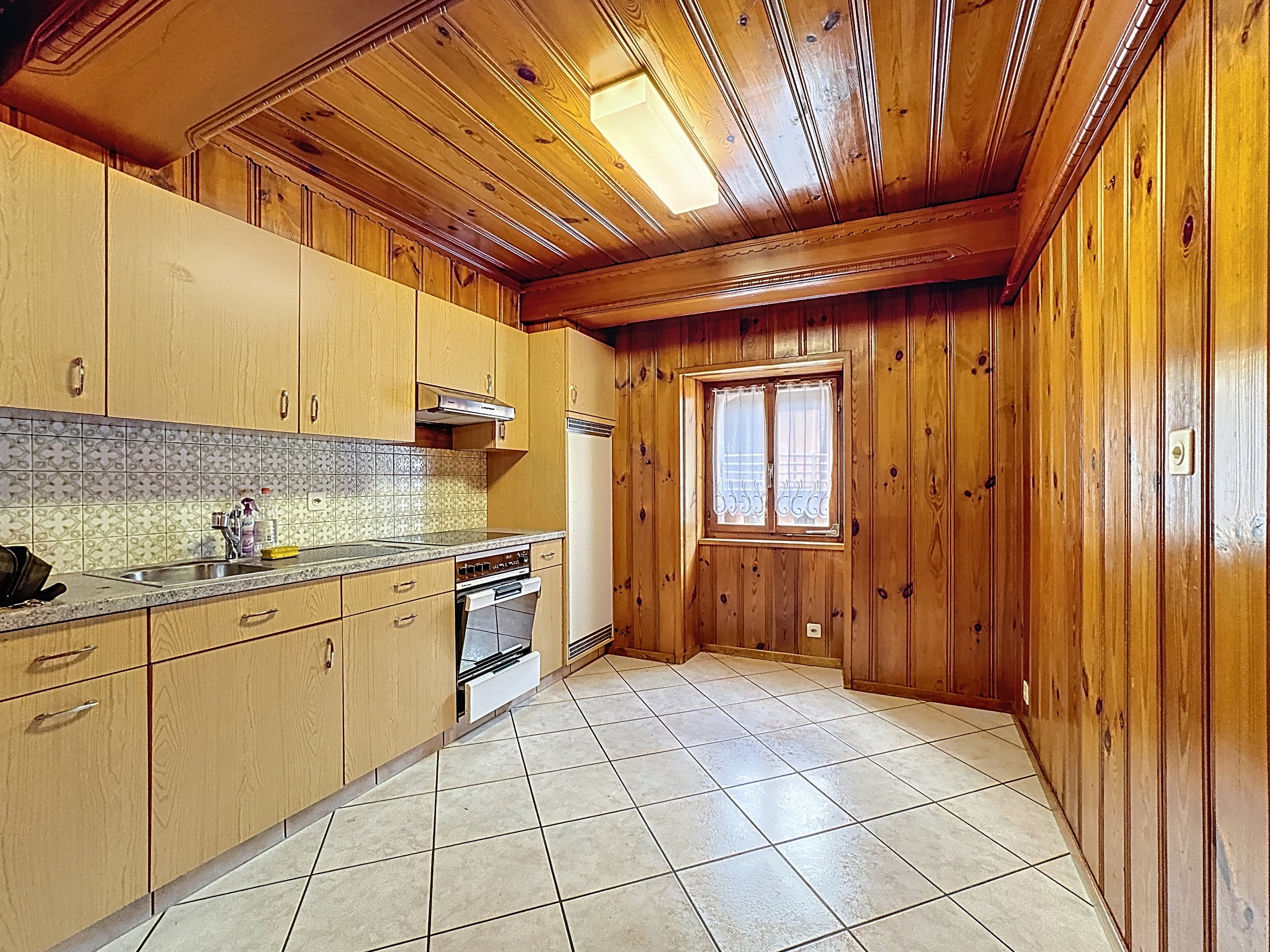 une grande cuisine avec des murs et des armoires en bois