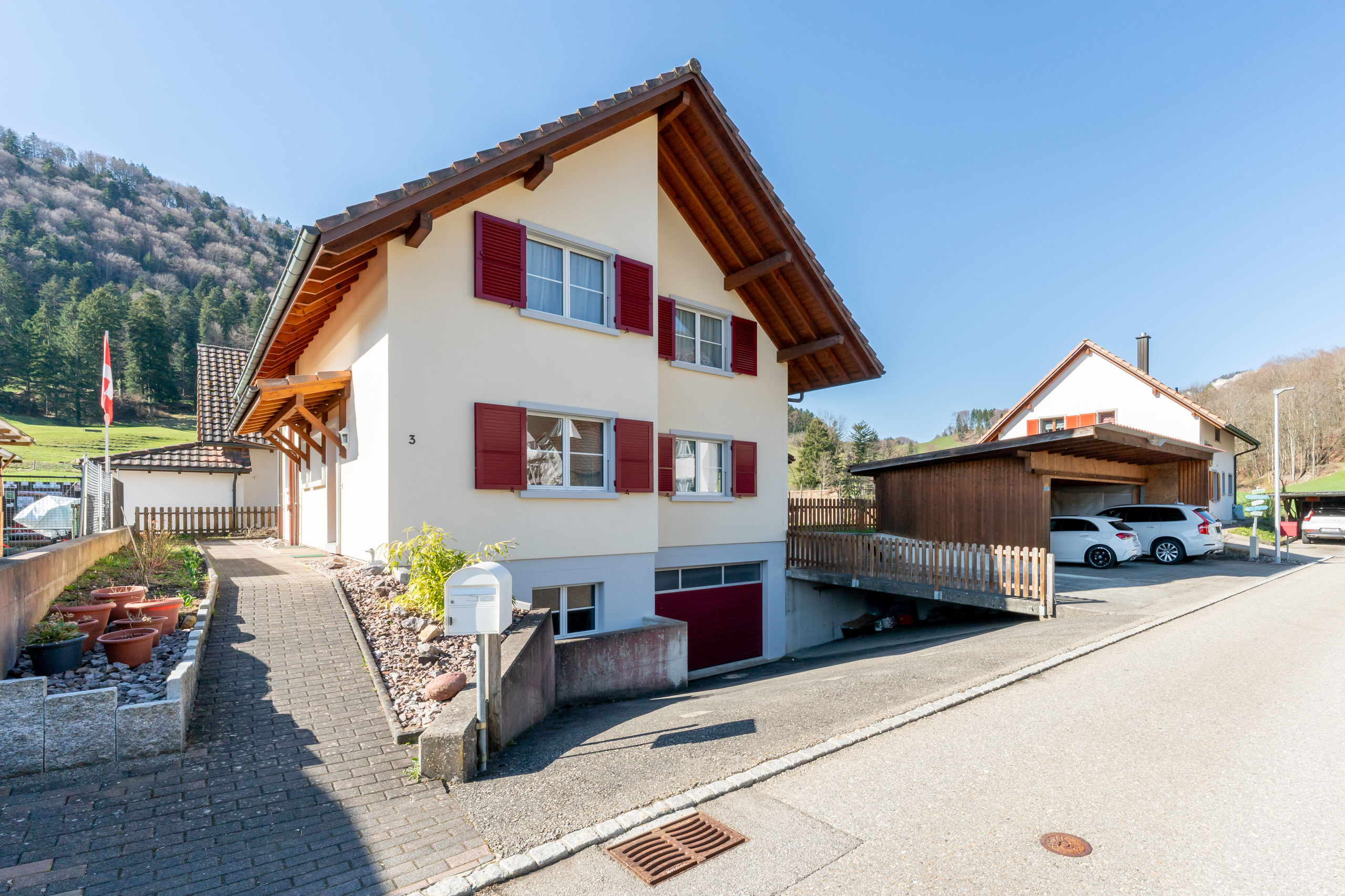 Hauszugang mit Aussenparkplätzen, Carports und Garagenzufahrt