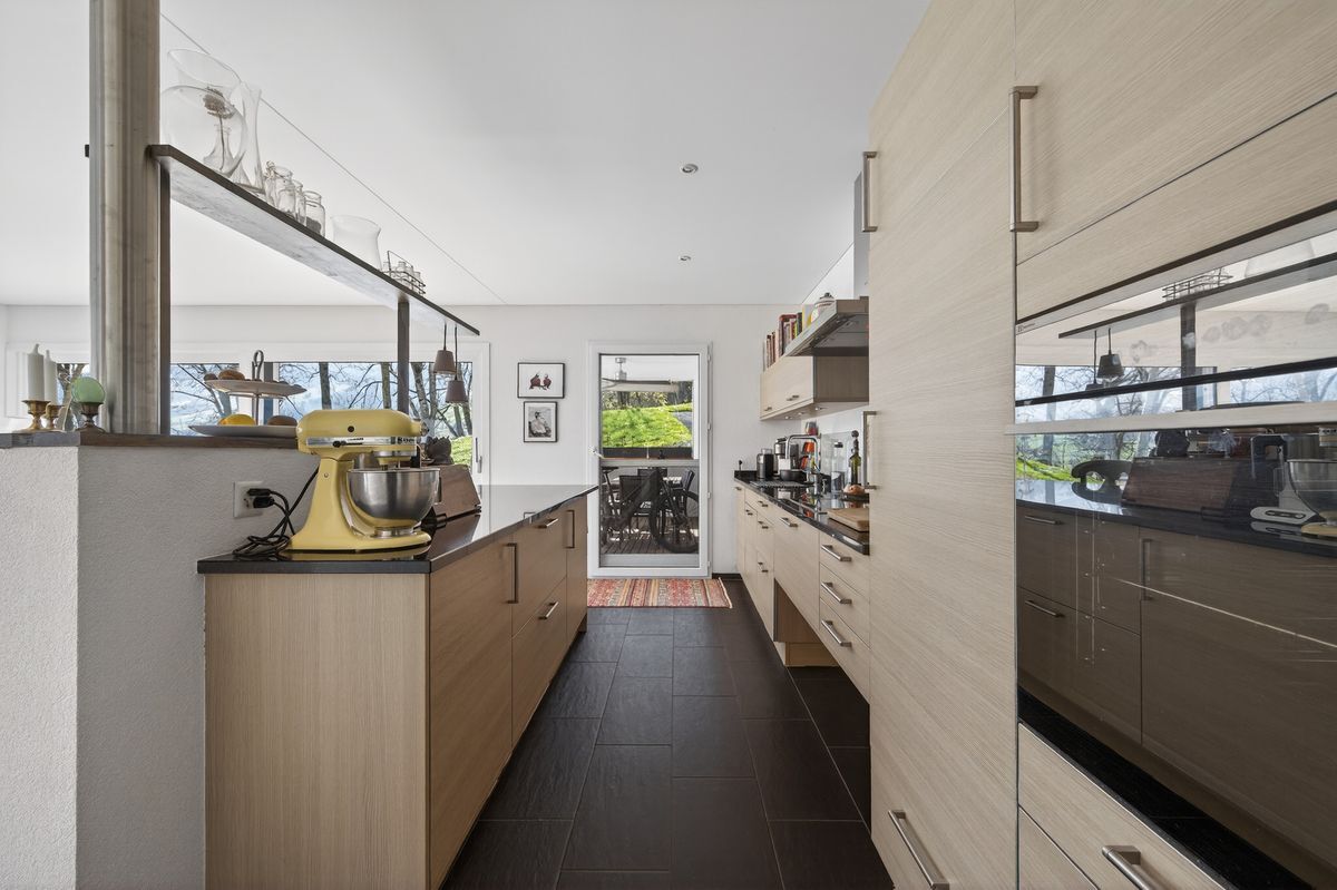 Hochwertige moderne Küche mit Holzfronten und Zugang zur Terrasse