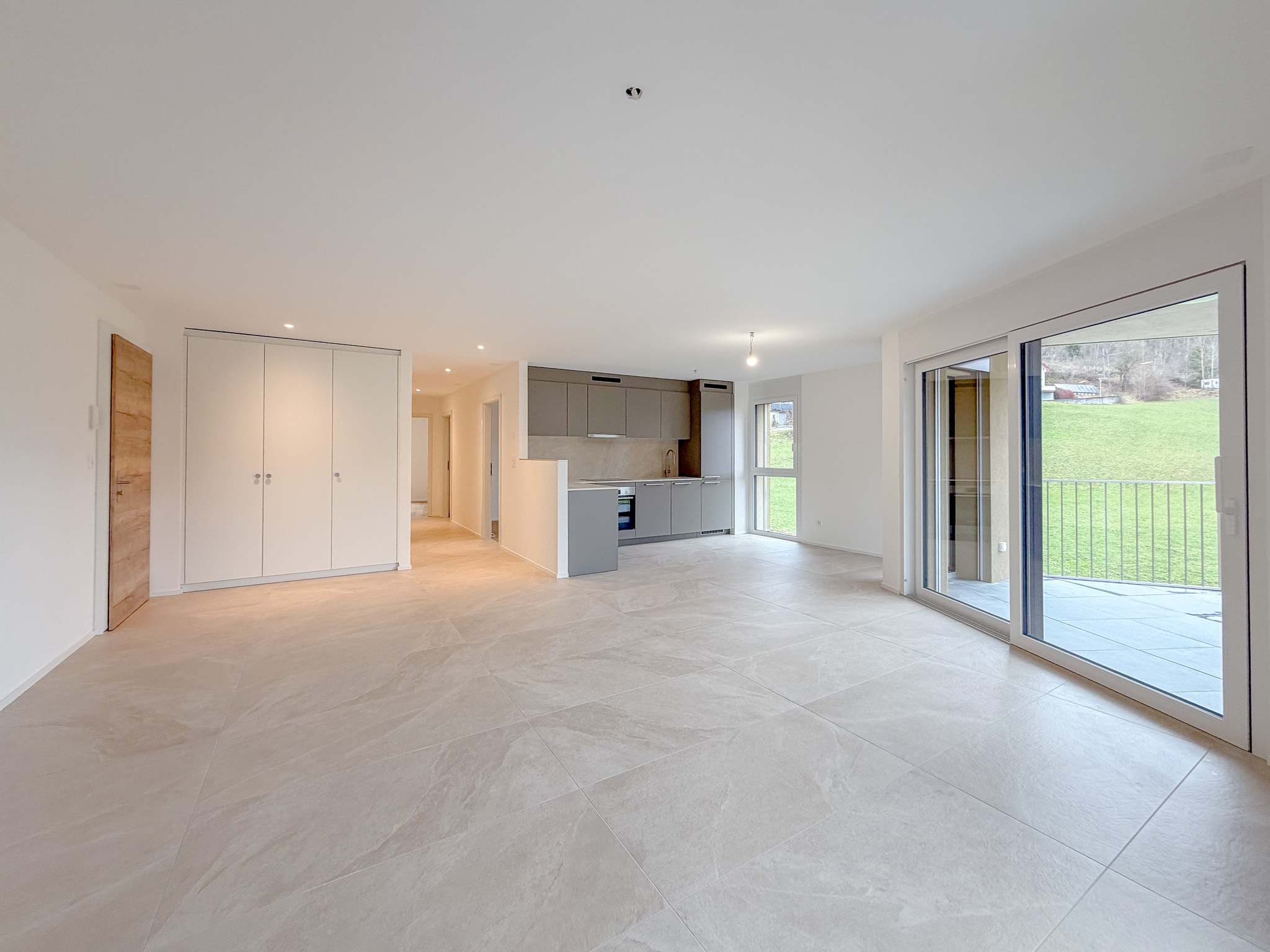 Espace salon/séjour avec portes-fenêtres donnant accès au balcon