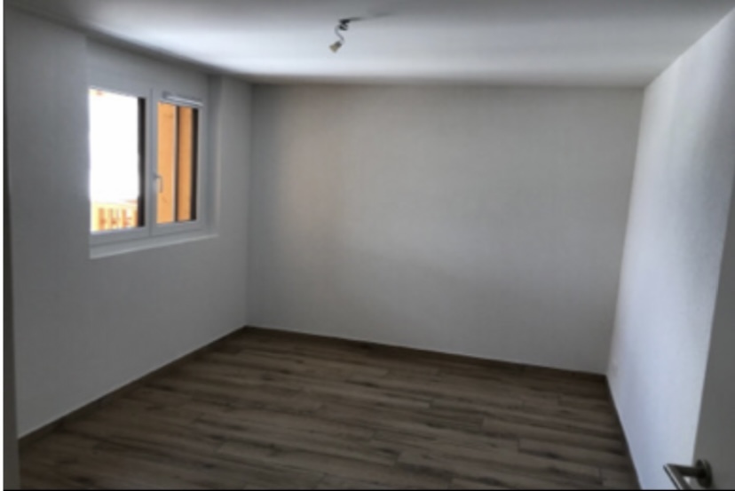 une chambre vide avec une grande fenêtre et du parquet une chambre vide avec une grande fenêtre et du parquet