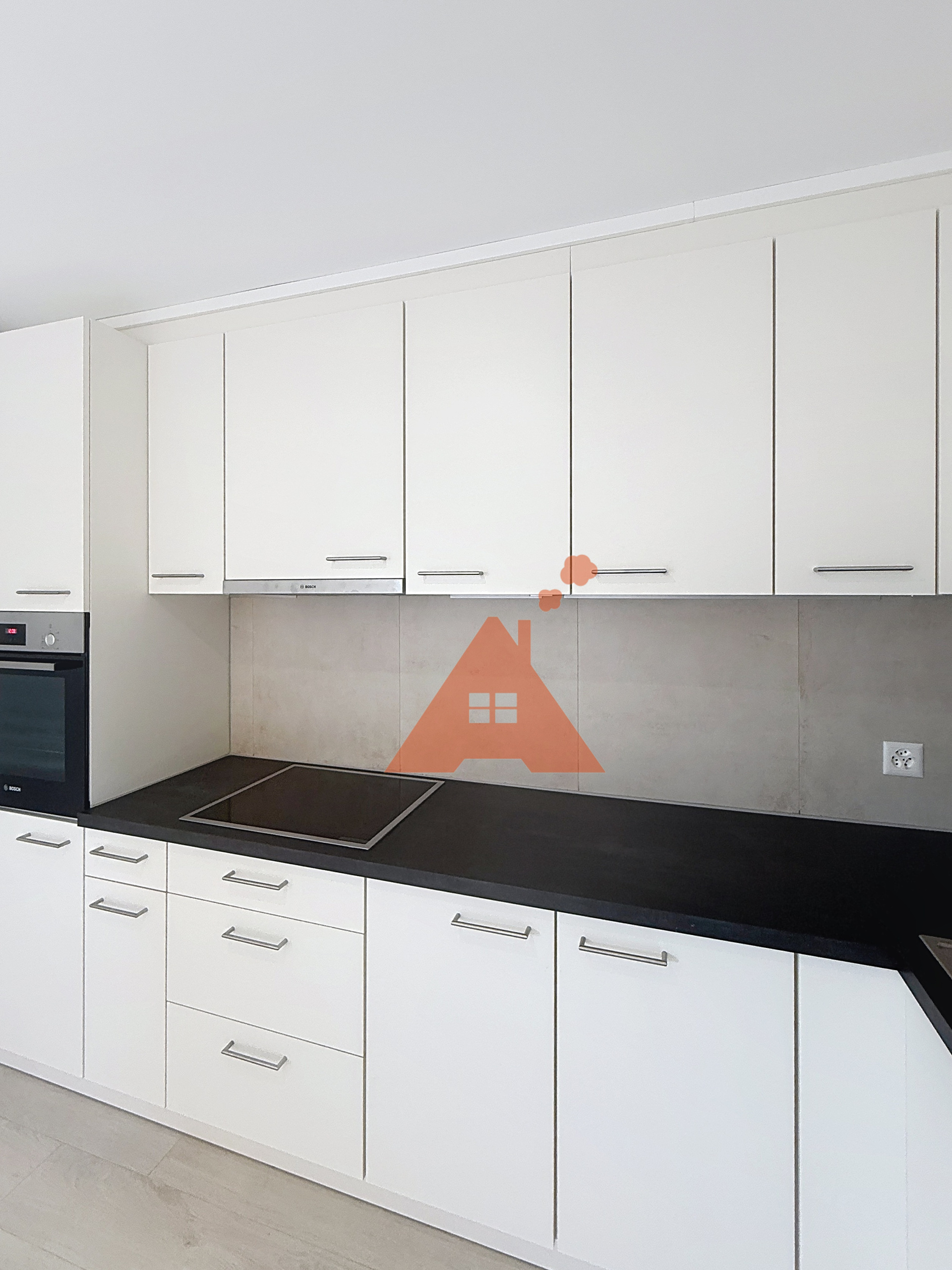 une cuisine moderne avec des armoires blanches et des comptoirs noirs une cuisine moderne avec des armoires blanches et des comptoirs noirs