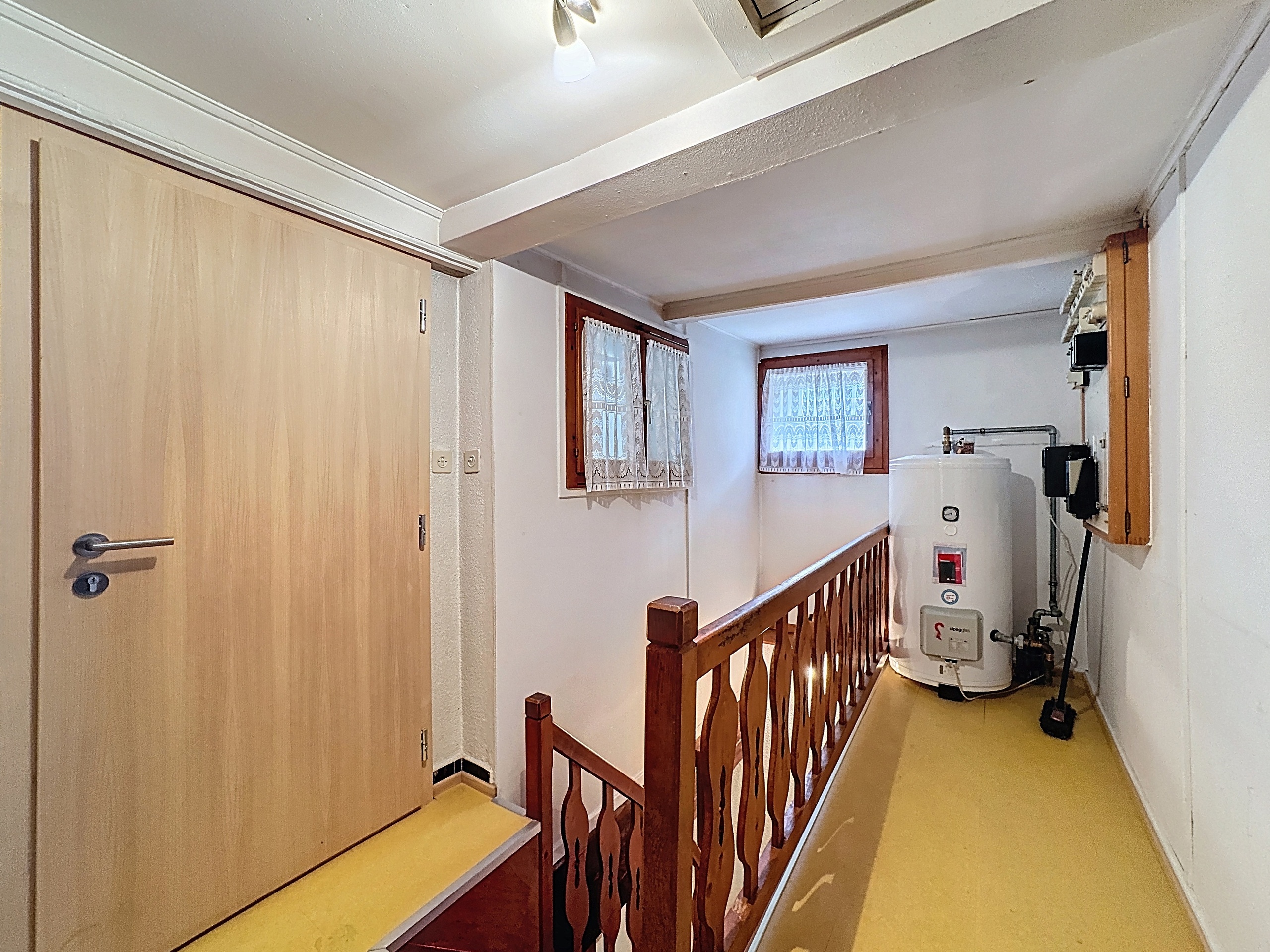 un couloir avec une porte en bois menant à une autre pièce