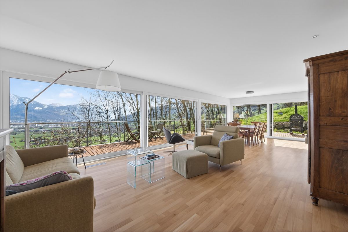 Grosszügiger Wohnbereich mit Panoramasicht auf die Berge und Zugang zur Terrasse