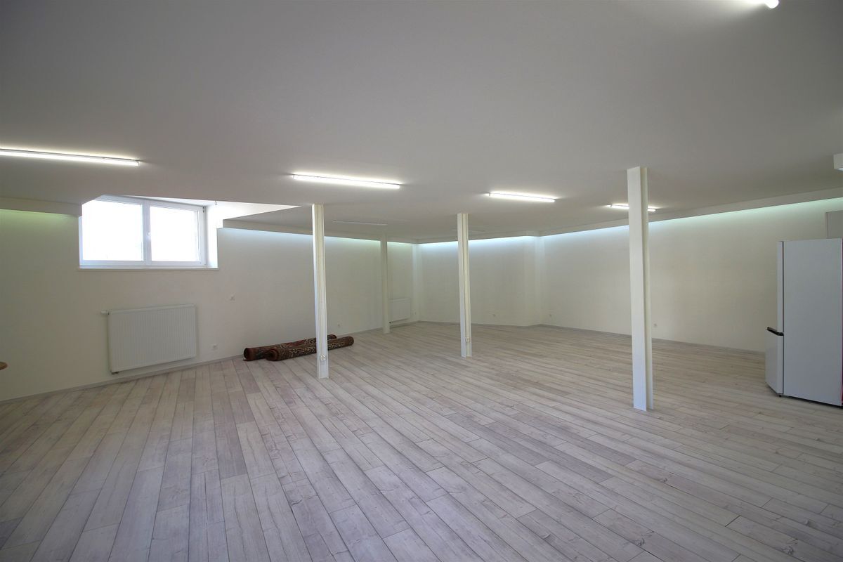 Grand espace avec sol en bois et lumière naturelle abondante.