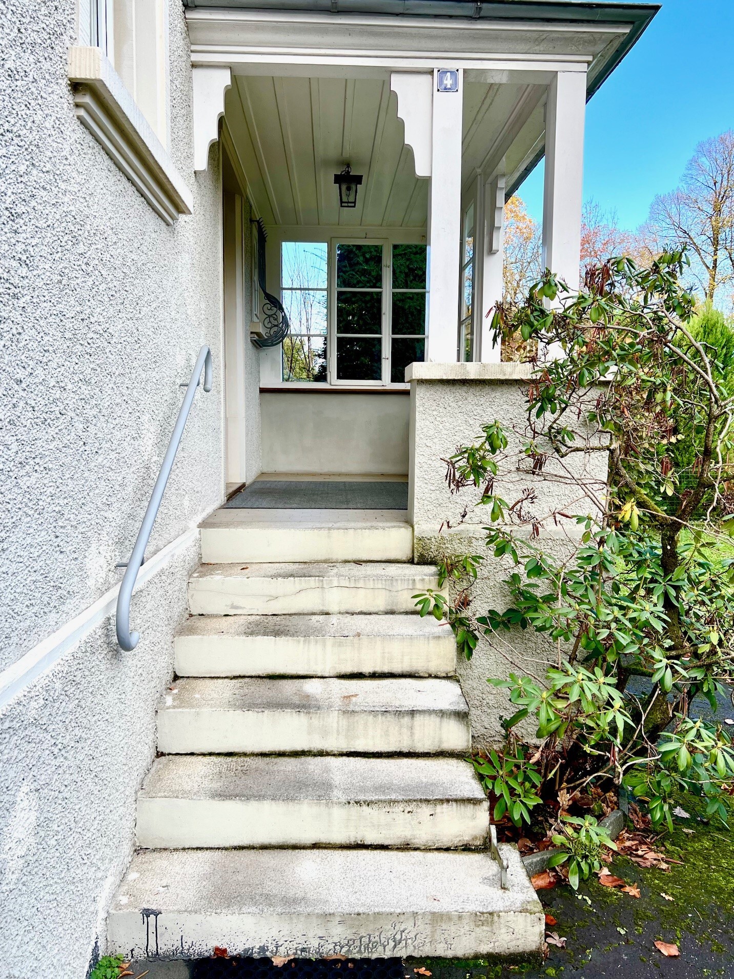 a white house with steps leading up to the front door