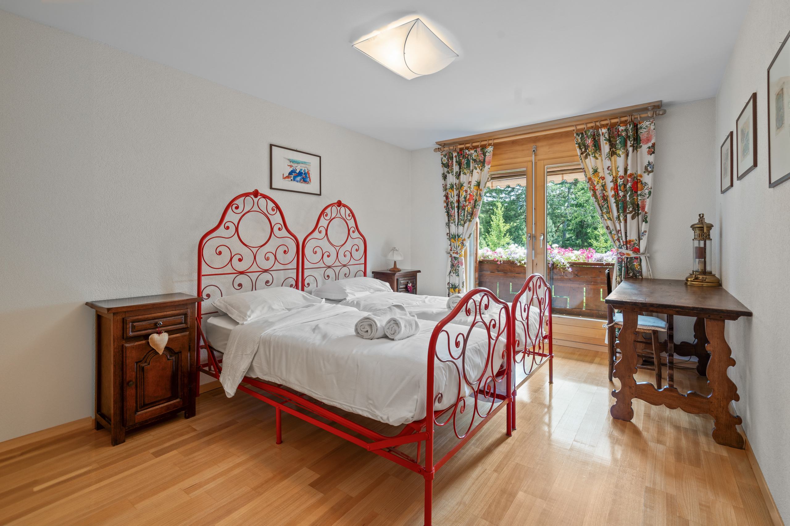 une chambre avec du parquet, une grande fenêtre et un lit blanc une chambre avec du parquet, une grande fenêtre et un lit blanc