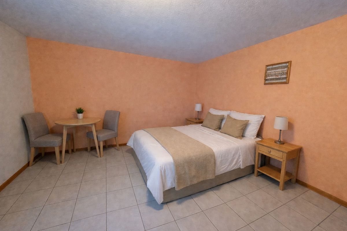 Chambre avec lit double et coin salon.