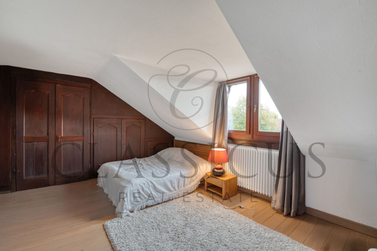 Chambre mansardée avec placards en bois et fenêtre lumineuse. Chambre mansardée avec placards en bois et fenêtre lumineuse.