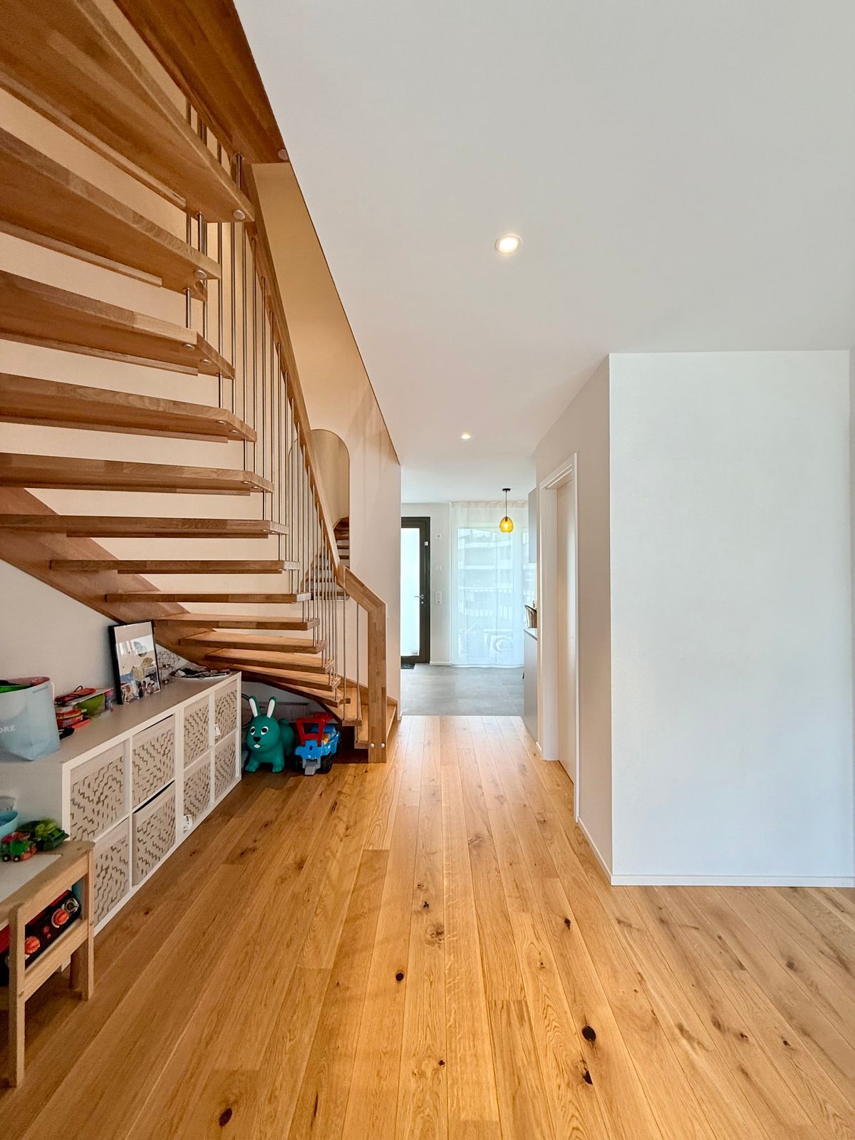 Couloir accédant à l'escalier menant aux chambres. Cet espace ouvre sur la cuisine, le salon ainsi que la salle à manger. On accède aussi à la buanderie ainsi qu'à une salle de douche avec WC.  Couloir accédant à l'escalier menant aux chambres. Cet espace ouvre sur la cuisine, le salon ainsi que la salle à manger. On accède aussi à la buanderie ainsi qu'à une salle de douche avec WC.