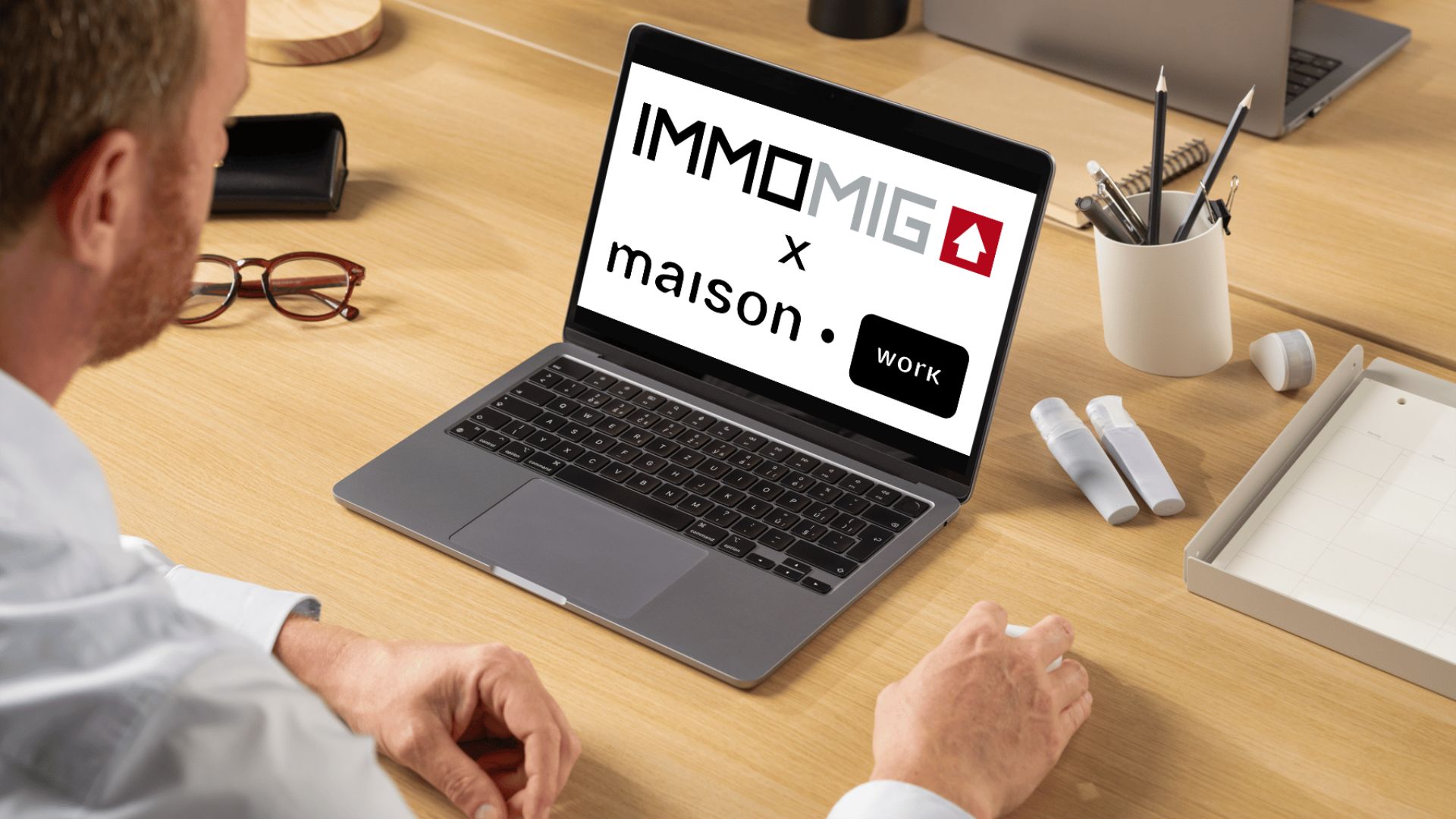 Partnership between IMMOMIG SA and maison.work displayed on a laptop, illustrating the integration of digital solutions for real estate professionals.